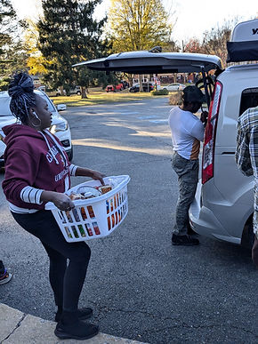 Holiday Giving volunteers distribute Thanksgiving food and gift cards to local families.