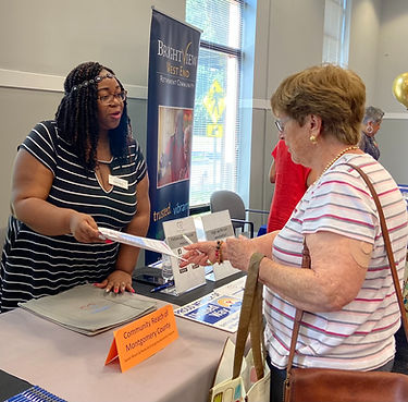 REAP Director Odeth Berlin providing information to local residents at a tabling event