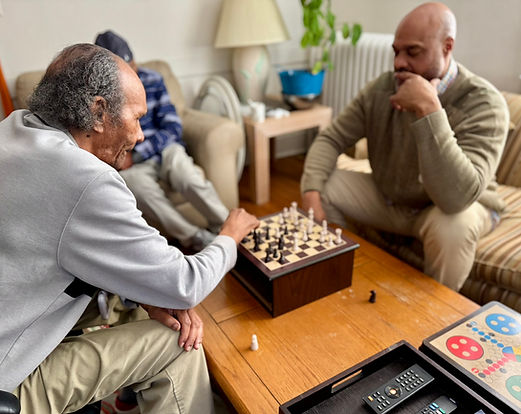 Ali playing chess with Jefferson House residents