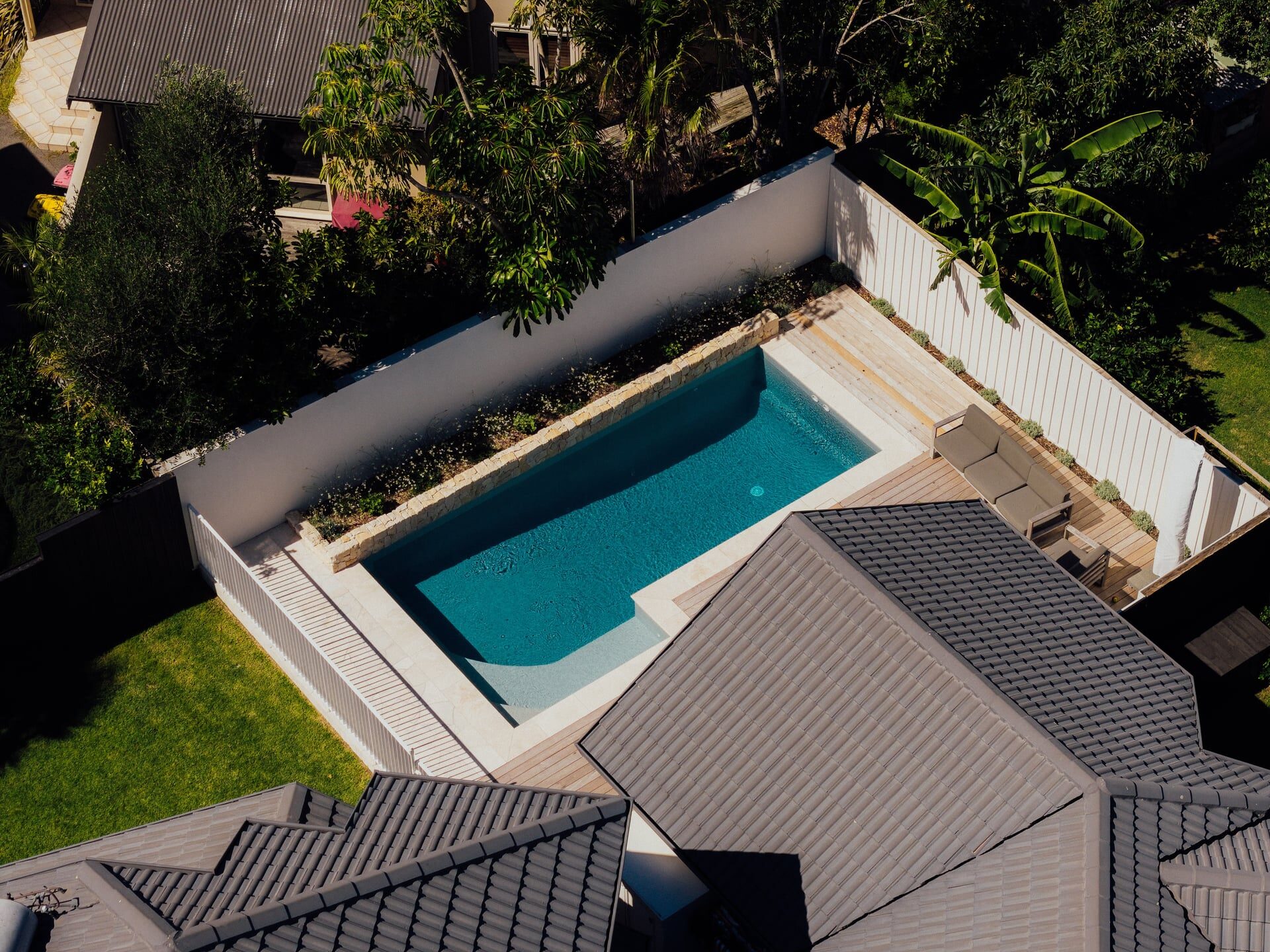 Timber deck with raised edging detail meeting manicured green lawn at Marine Parade landscaping project