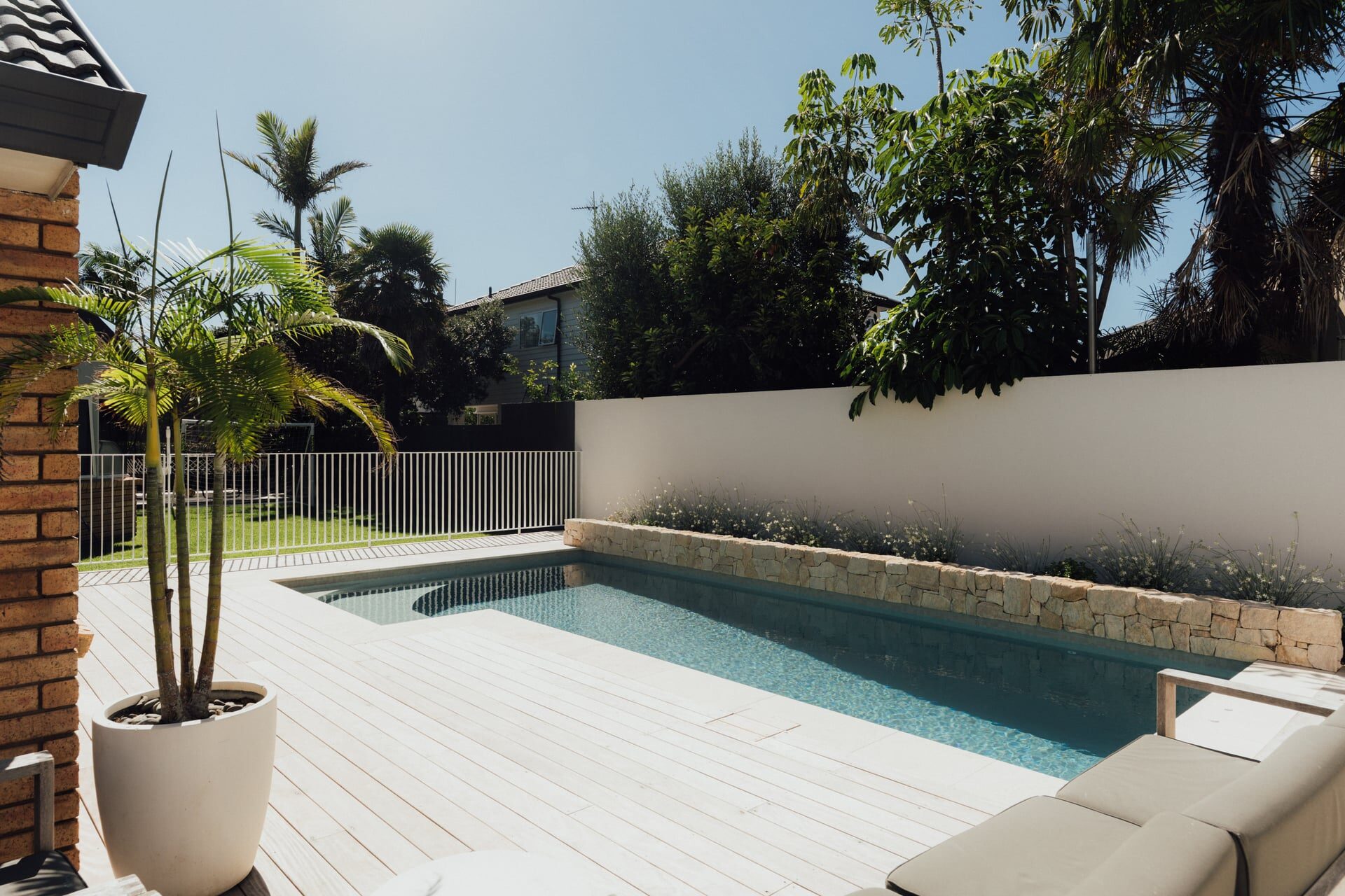 Natural stone steps with concrete retaining wall edges lawn and ornamental grasses at Marine Parade project