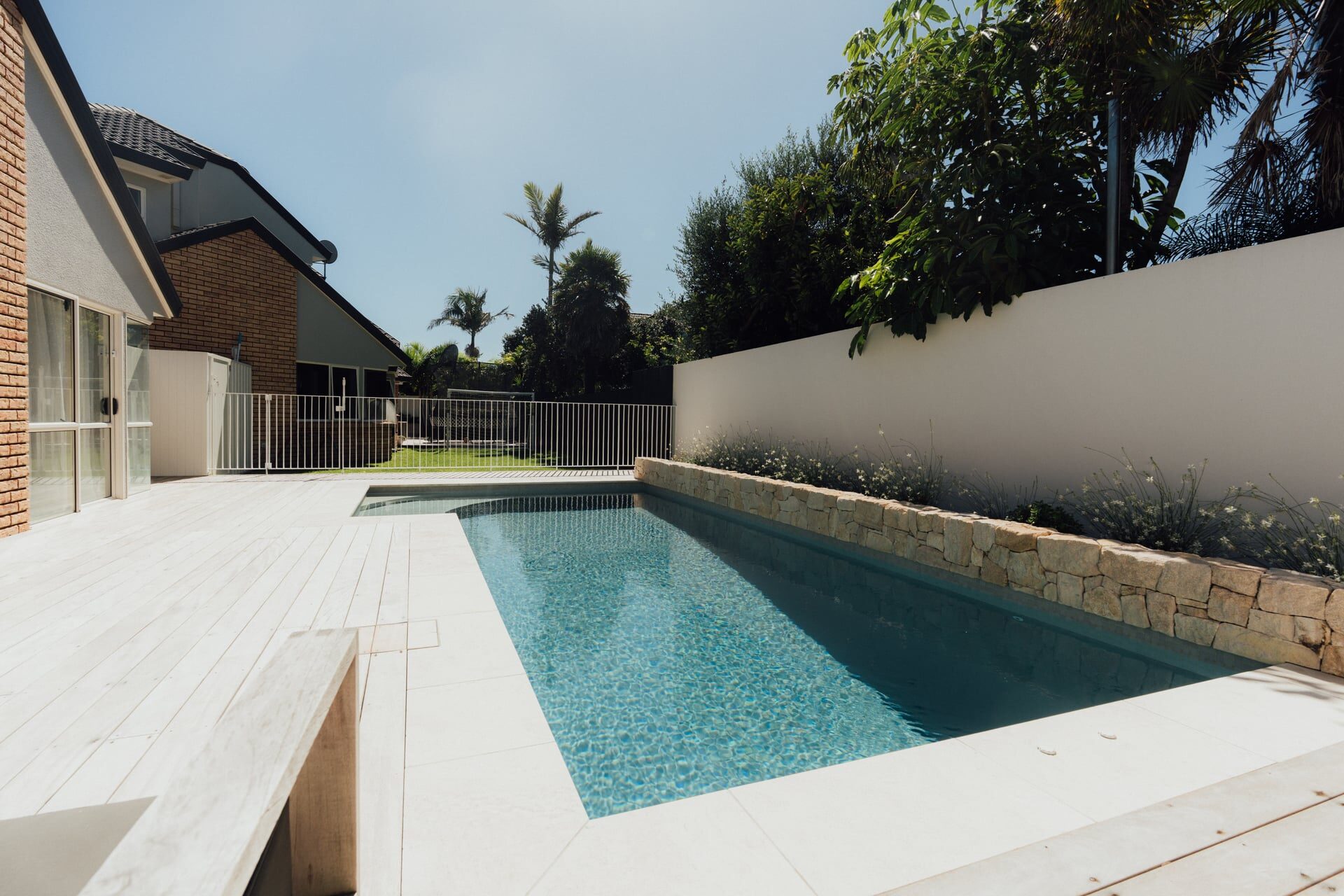 Stainless steel outdoor shower fixture mounted on timber panel cladding at Marine Parade project