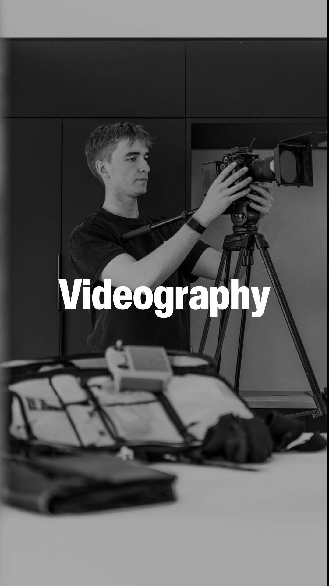 Person adjusting a professional video camera on a tripod indoors with videography text overlay.