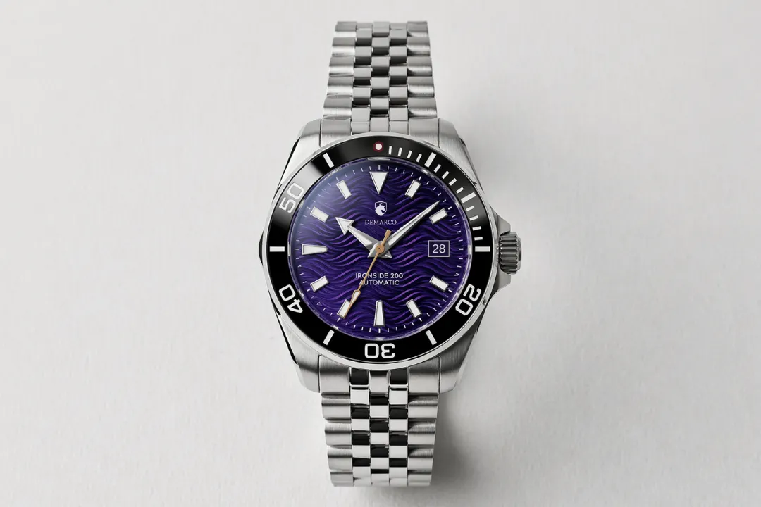 A DeMarco diver with a purple dial and black bezel on a steel jubilee bracelet