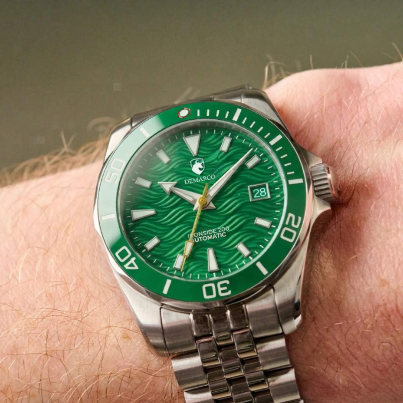 The DeMarco Ironside 200 in green, with a matching green bezel, worn on the wrist