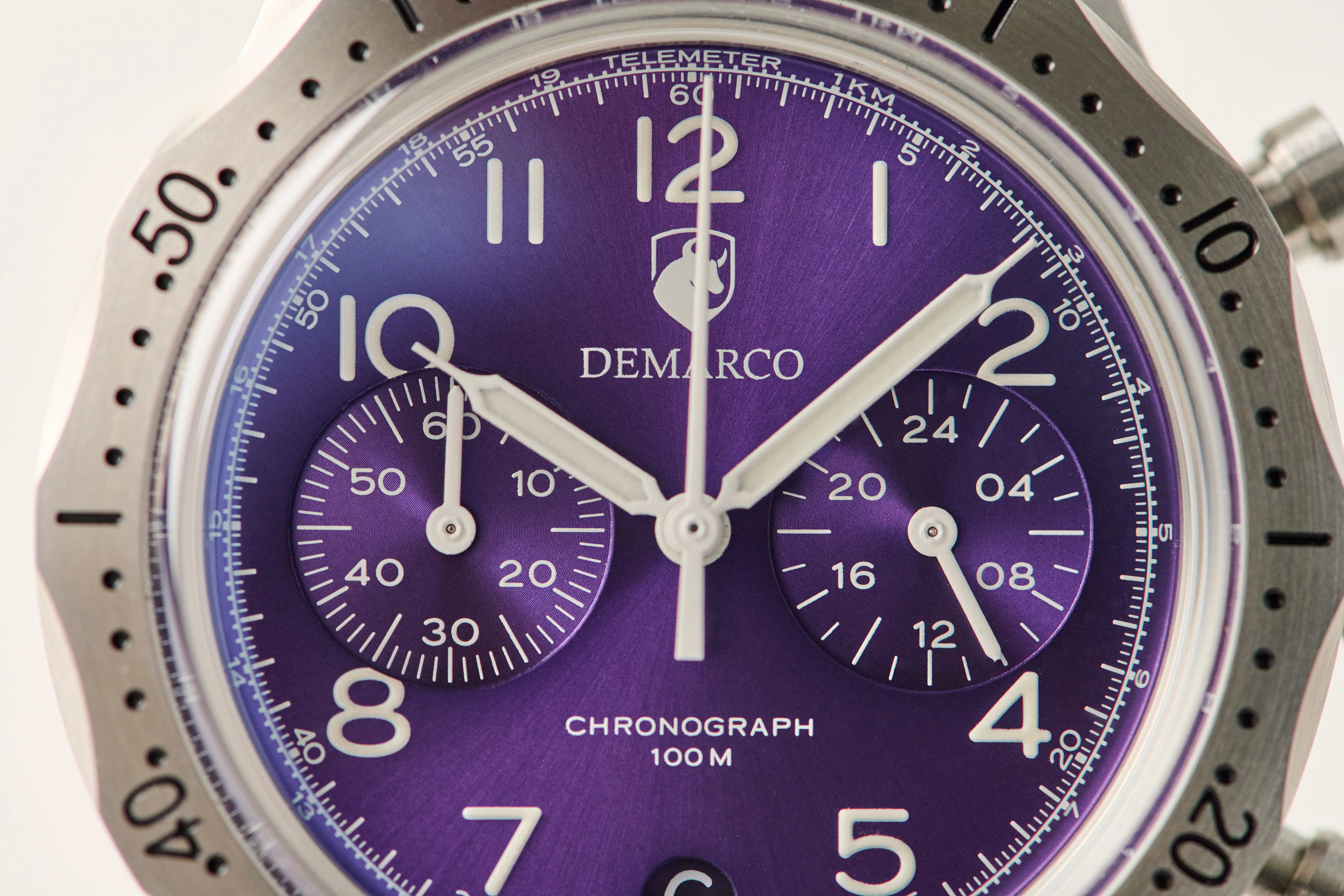Close up of a purple DeMarco chronograph dial, showing the telemeter scale and applied numerals