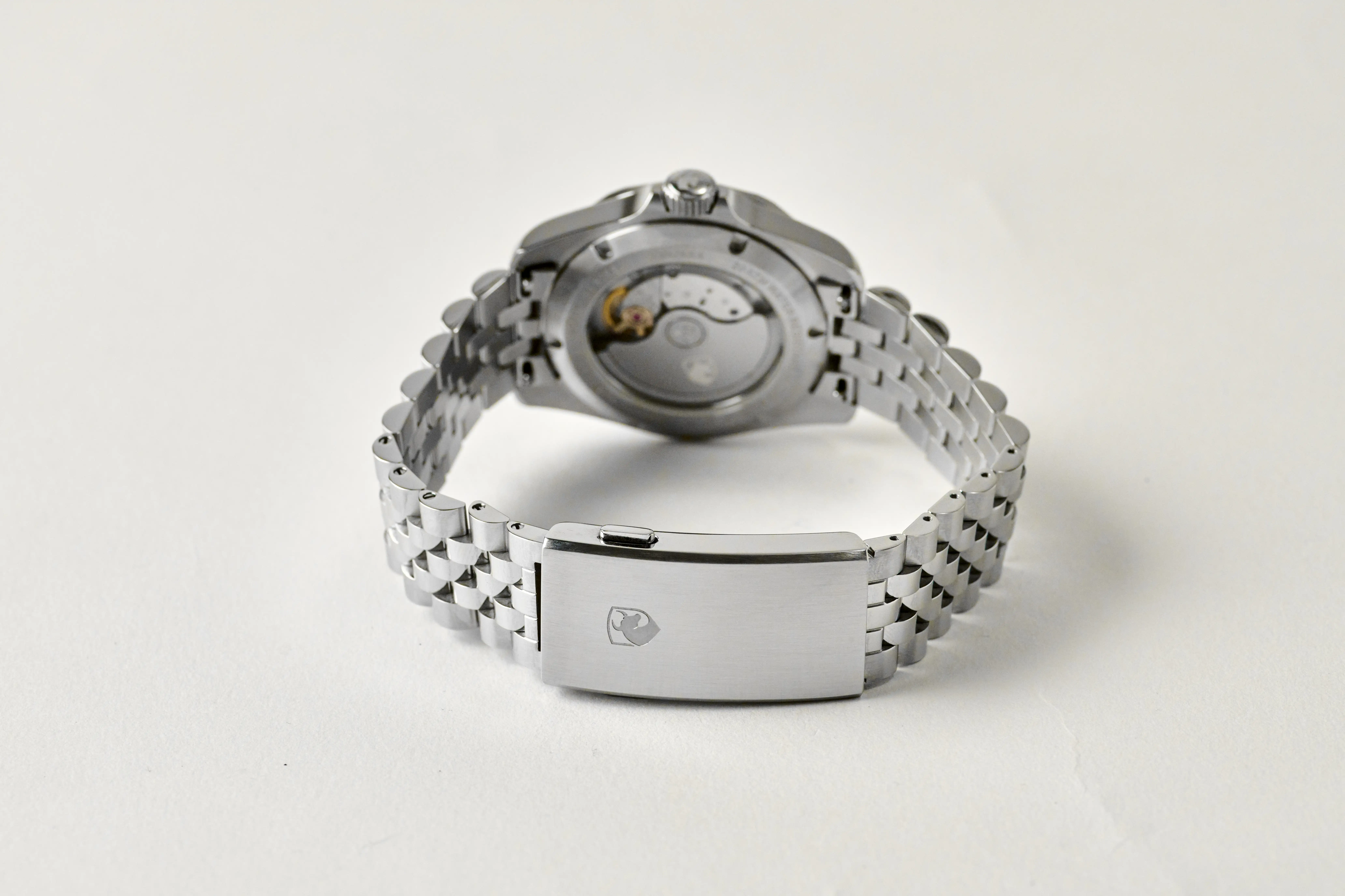 The DeMarco Ironside 200 seen from the back, its automatic movement visible through the sapphire display caseback, on a steel jubilee bracelet with a signed clasp
