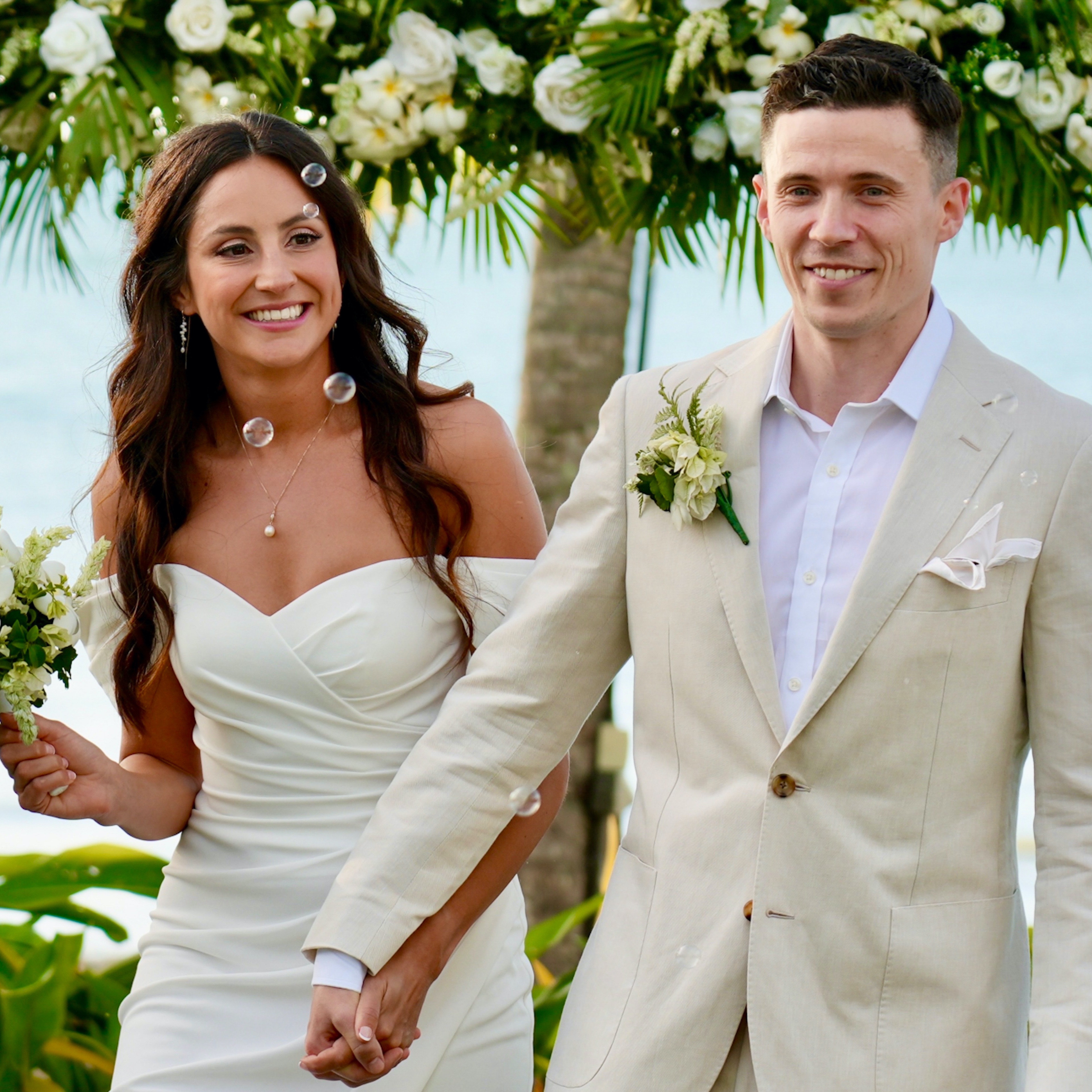 Bride and groom holding hands in the park.