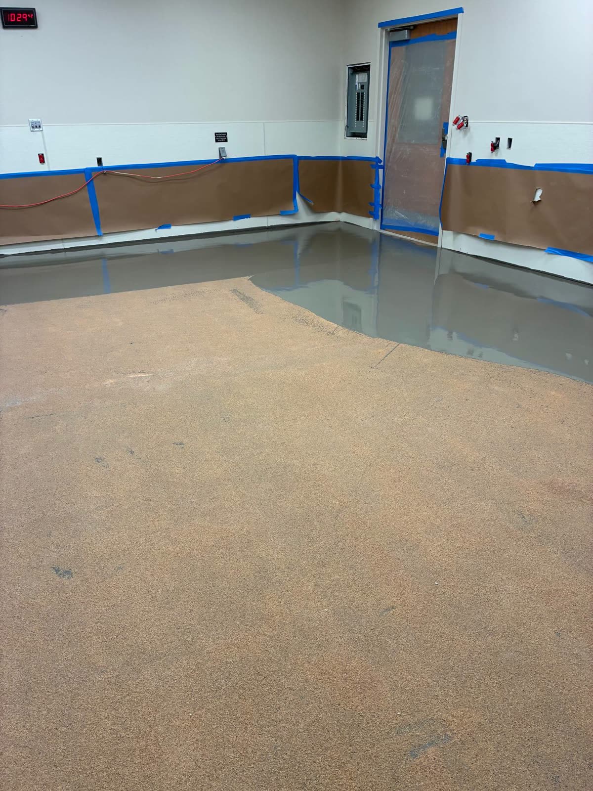 Self-leveling underlayment poured over a sand-broadcast mitigation coat