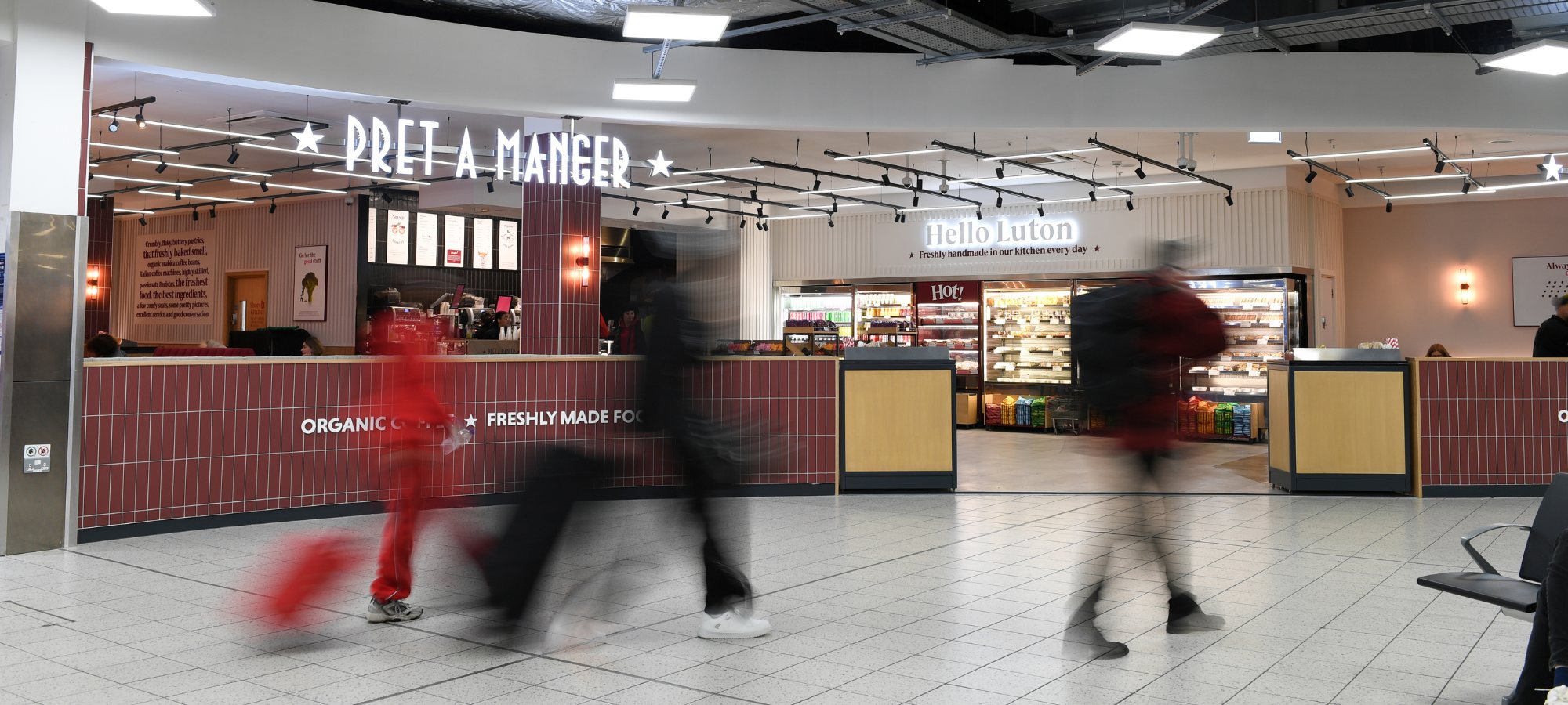 people walking through the aiport terminal pret in the background