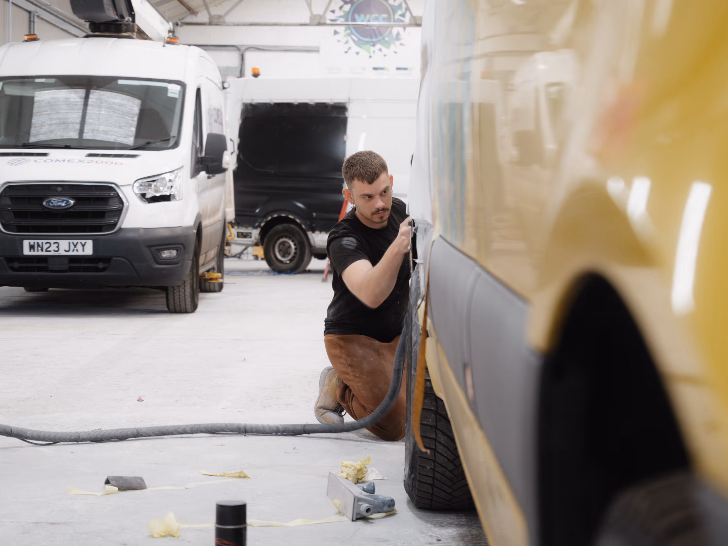 WCC staff member sanding the side of a van during accident repair.