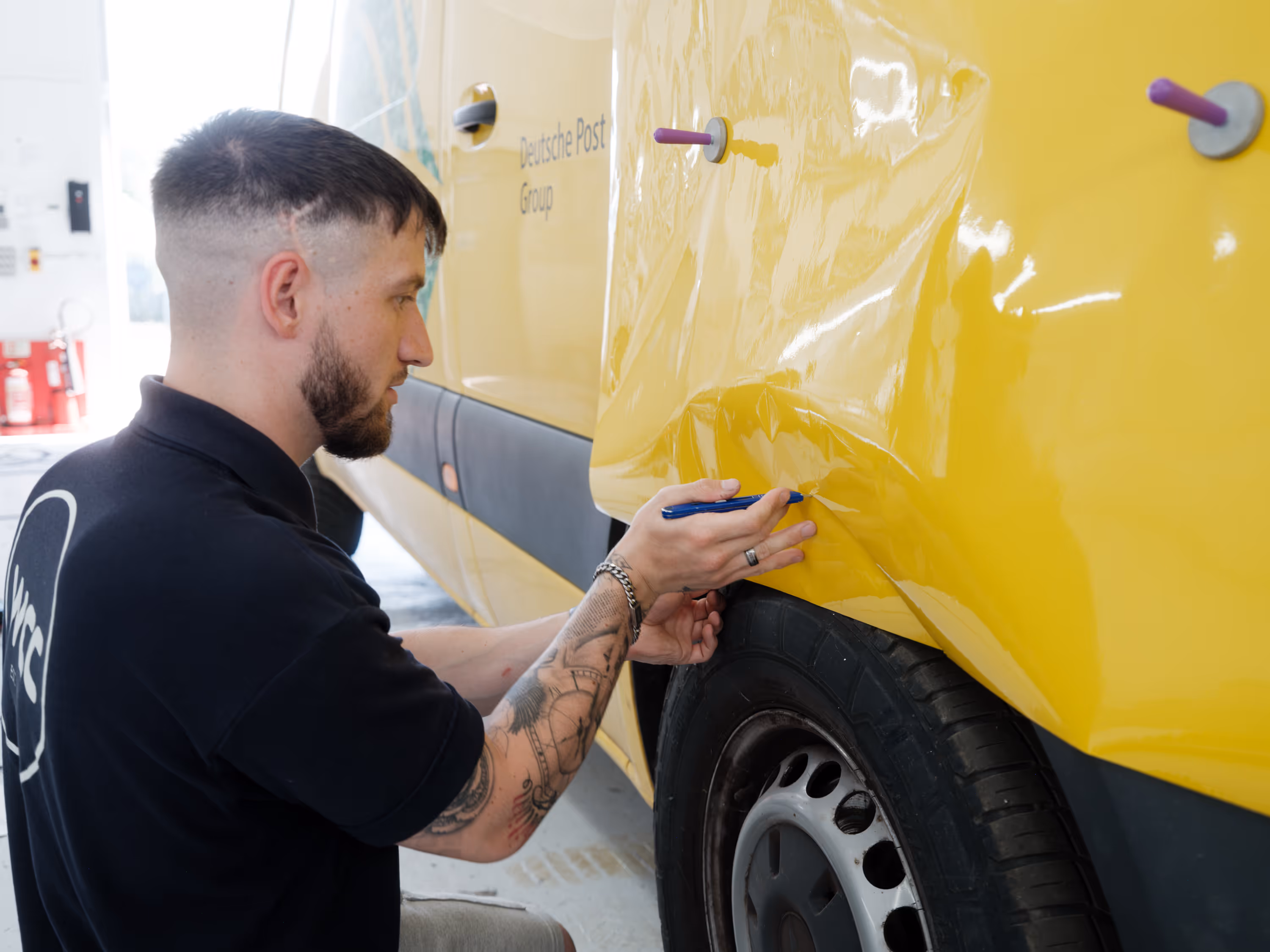WCC staff applying a new wrap to a DHL fleet van.