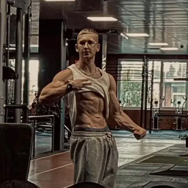 Oscar Straßburg zeigt definierte Bauchmuskeln im Fitnessstudio nach erfolgreicher Transformation