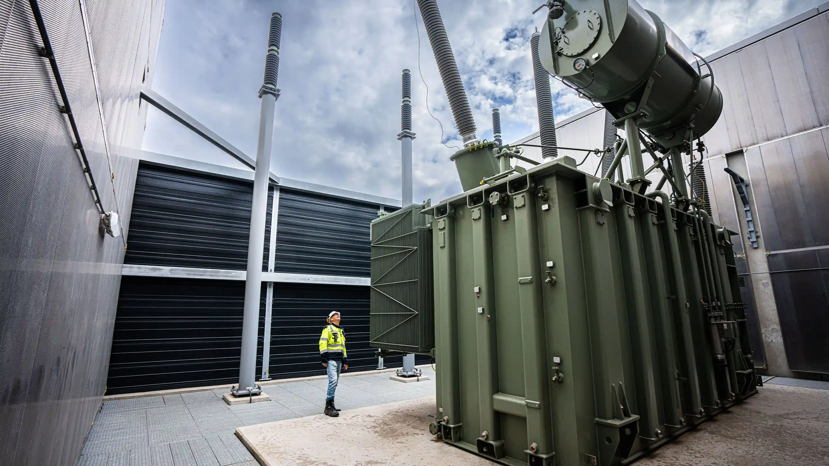 Large transformer installation with acoustic enclosures for noise control in the energy sector.