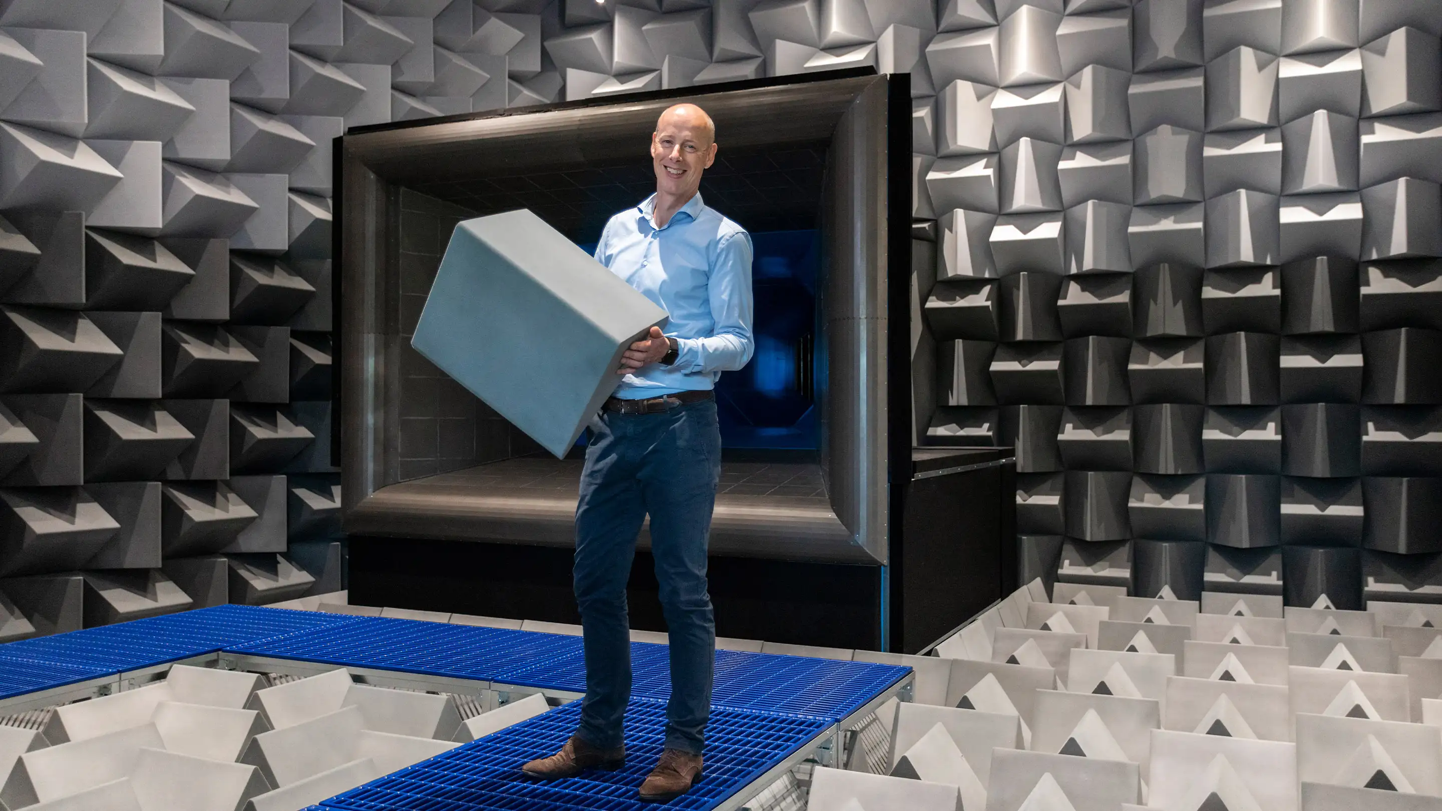 Merford employee in the anechoic chamber holding Flamex acoustic material.