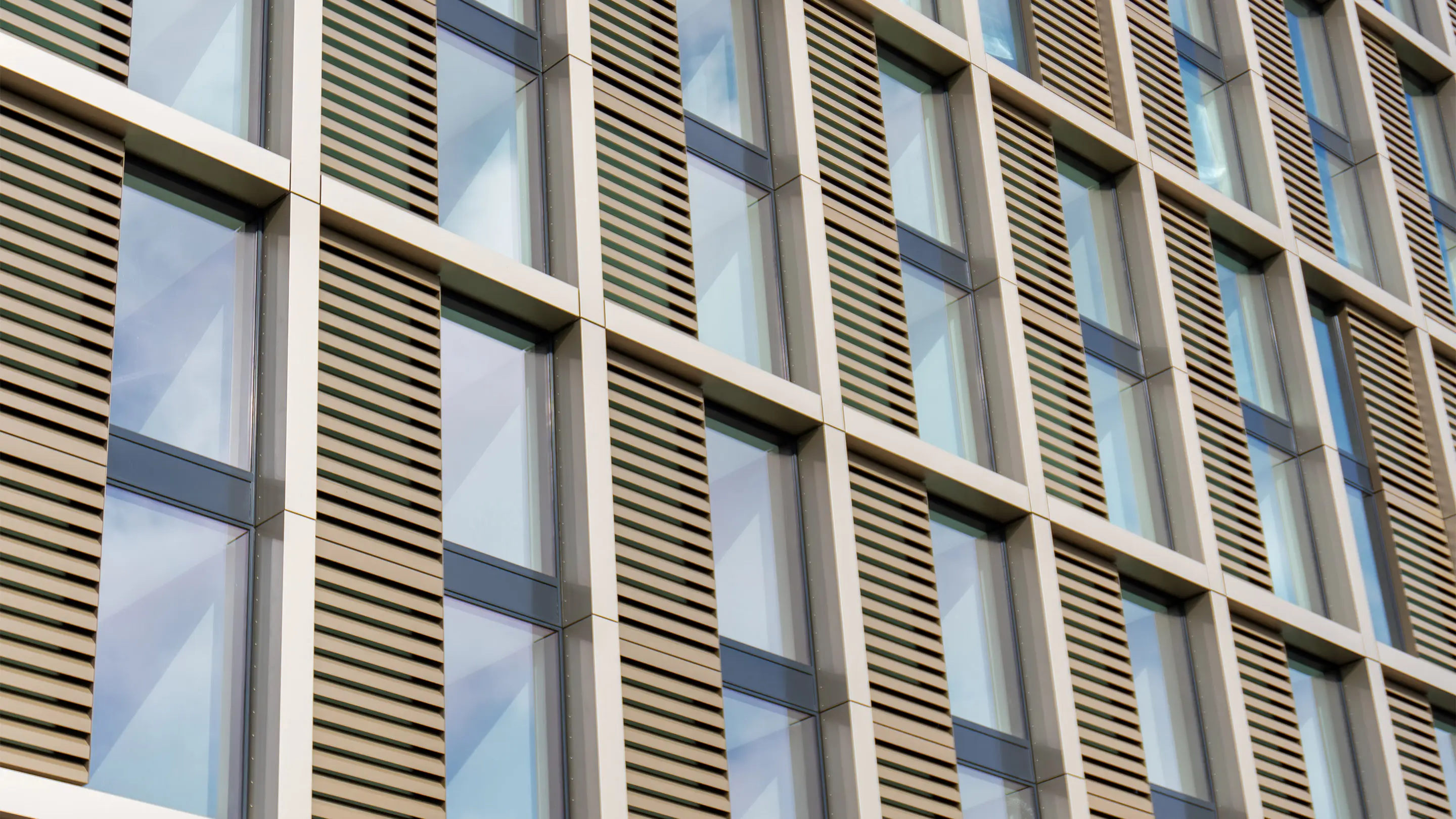 Close-up of a modern building facade with integrated AKR acoustic louvres providing sound insulation and ventilation.