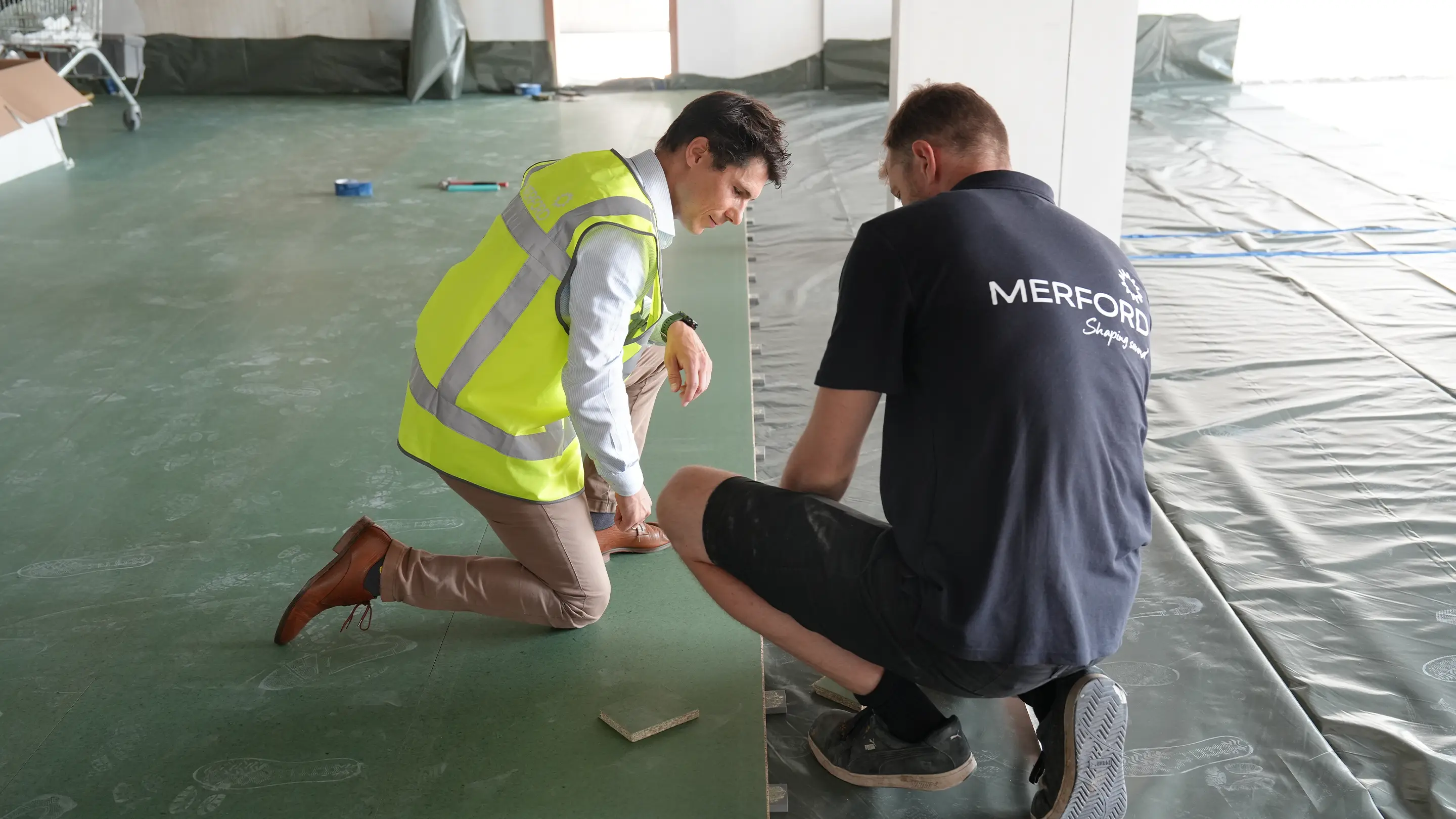 Merford employees working with floor insulation.