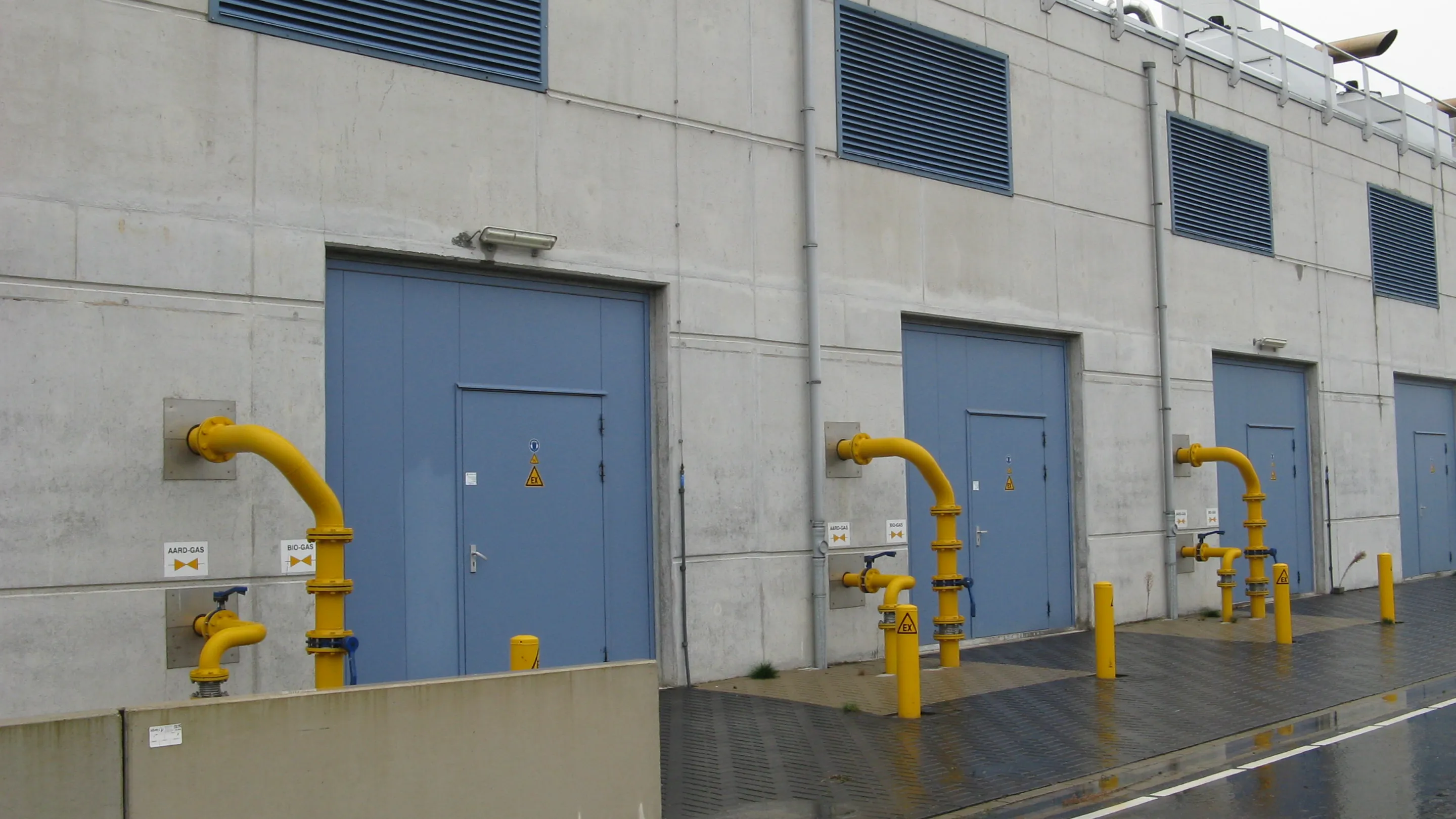 Aerial view of rooftop HVAC and cooling installations at a data centre, showing large ventilation units, pipework and surrounding greenery.