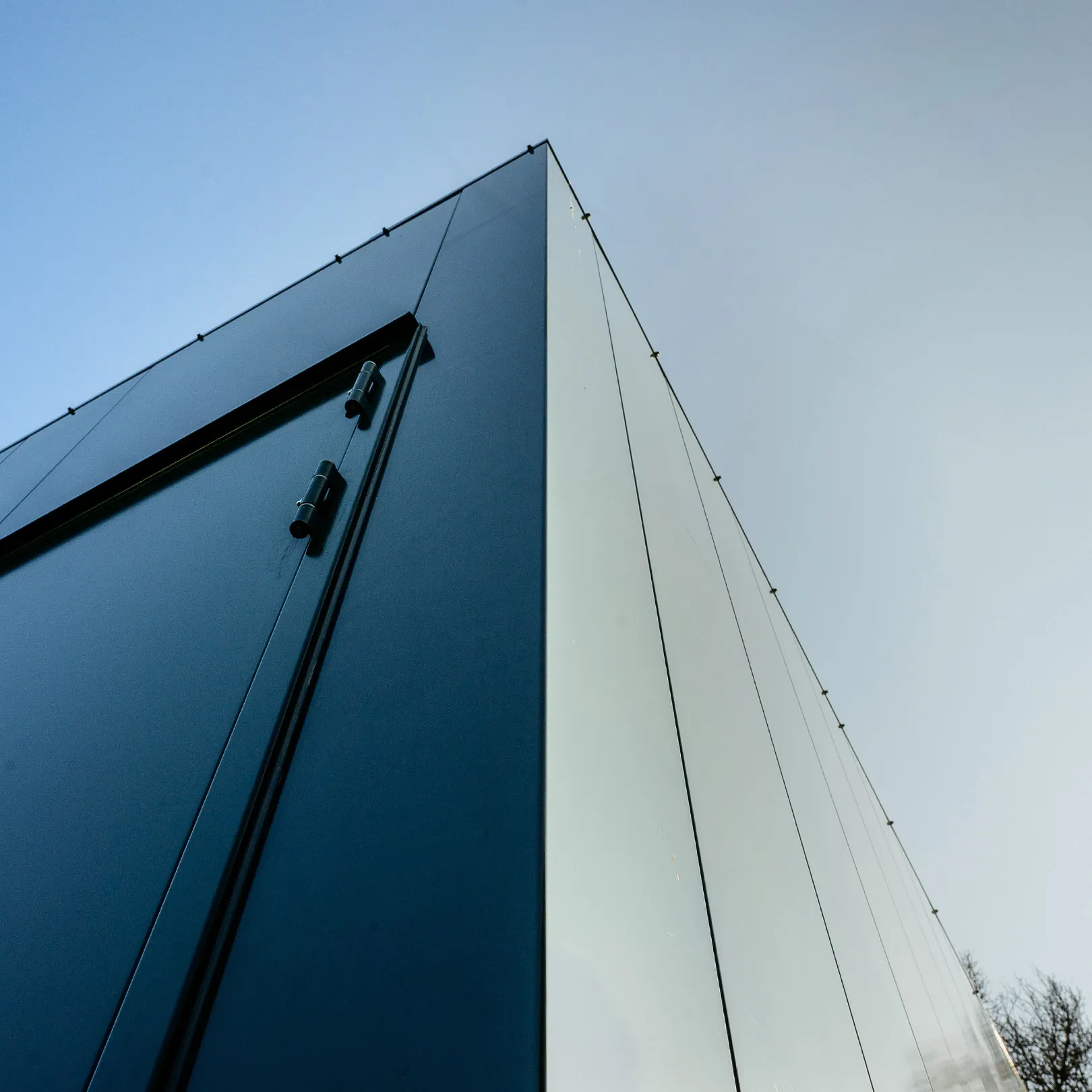Close-up view of noise barrier and steel door at Enexis tranformer station.