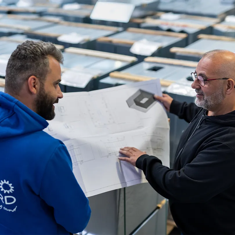 Merford engineers discussing a technical drawing in the production facility.