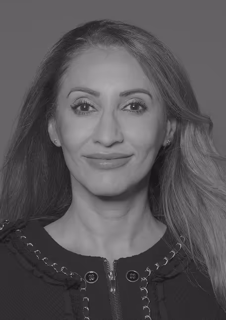 Portrait of a woman with long hair smiling slightly, wearing a zippered top with decorative stitching.