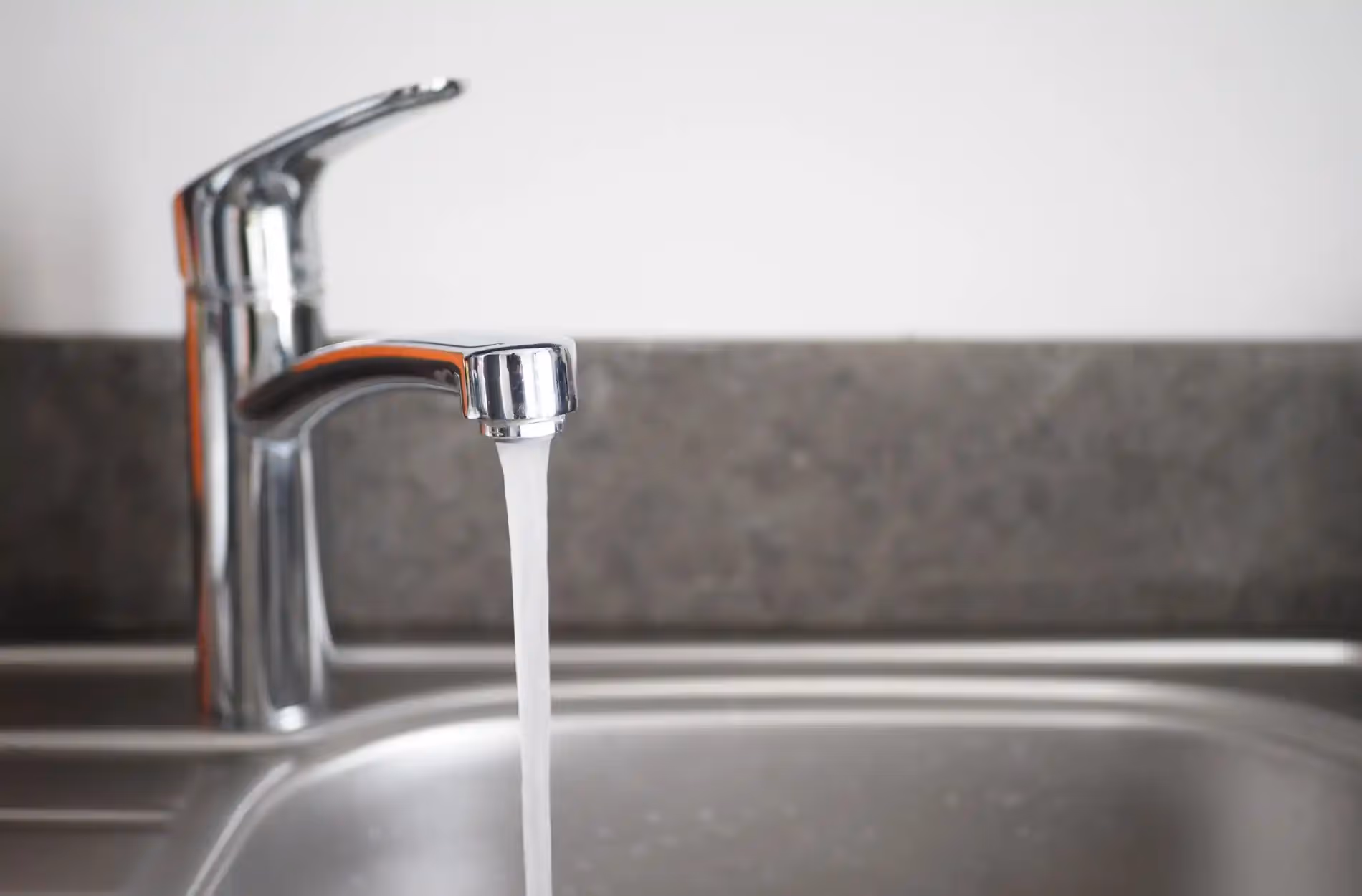 Water pouring from a kitchen faucet.