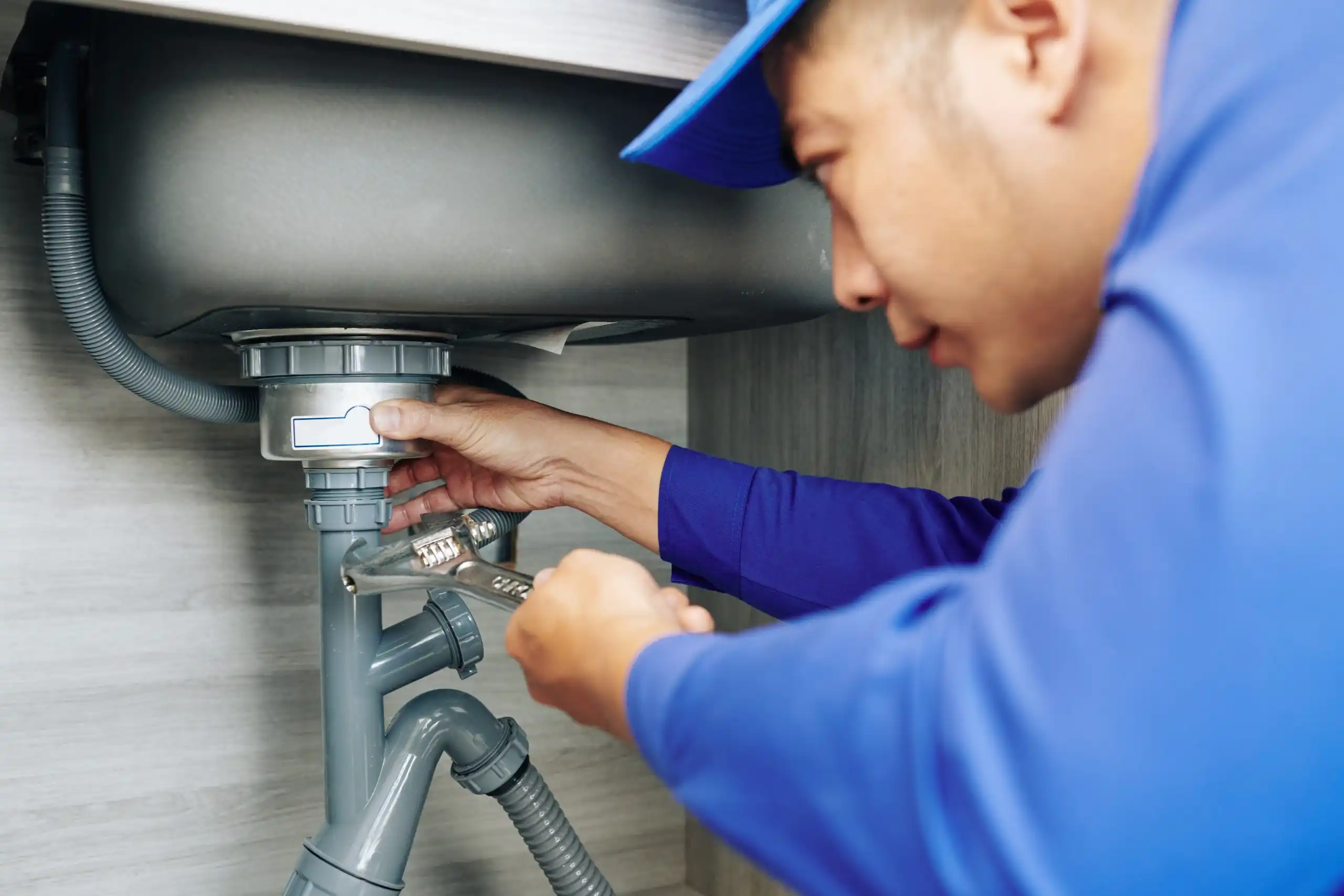 Plumber repairing a leaky drain.