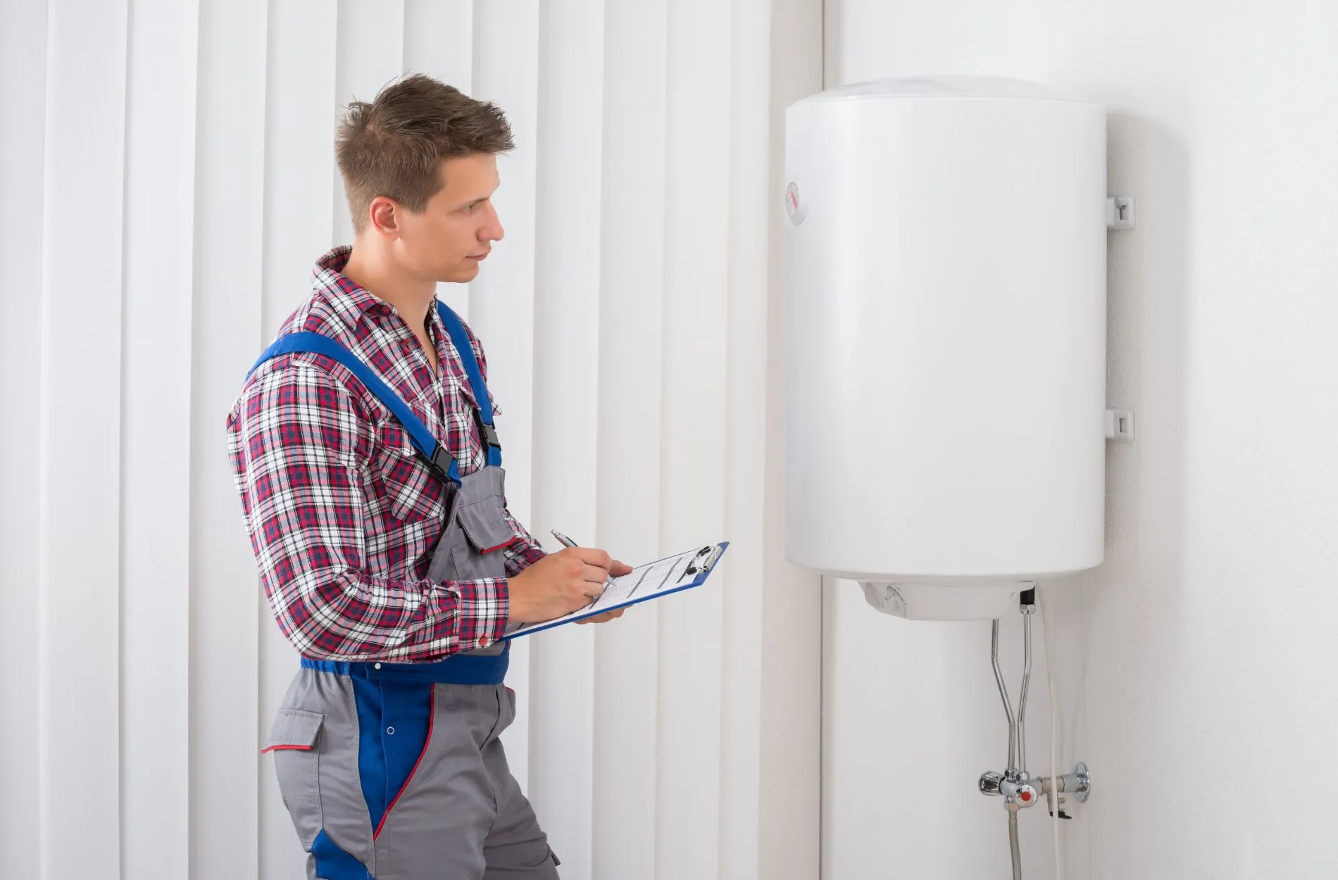 A plumber inspecting A tankless water heater 
