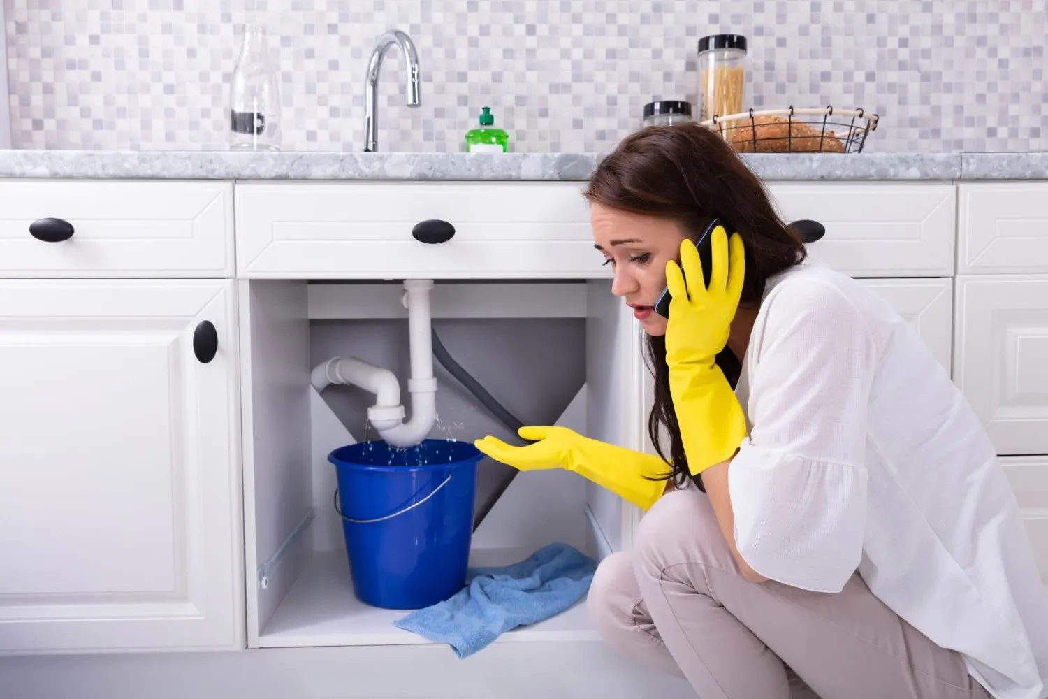 Woman calling plumber for leak.