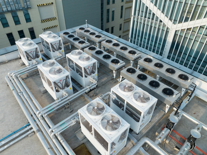 Rooftop view of industrial air conditioning units with large ducts and fans. 