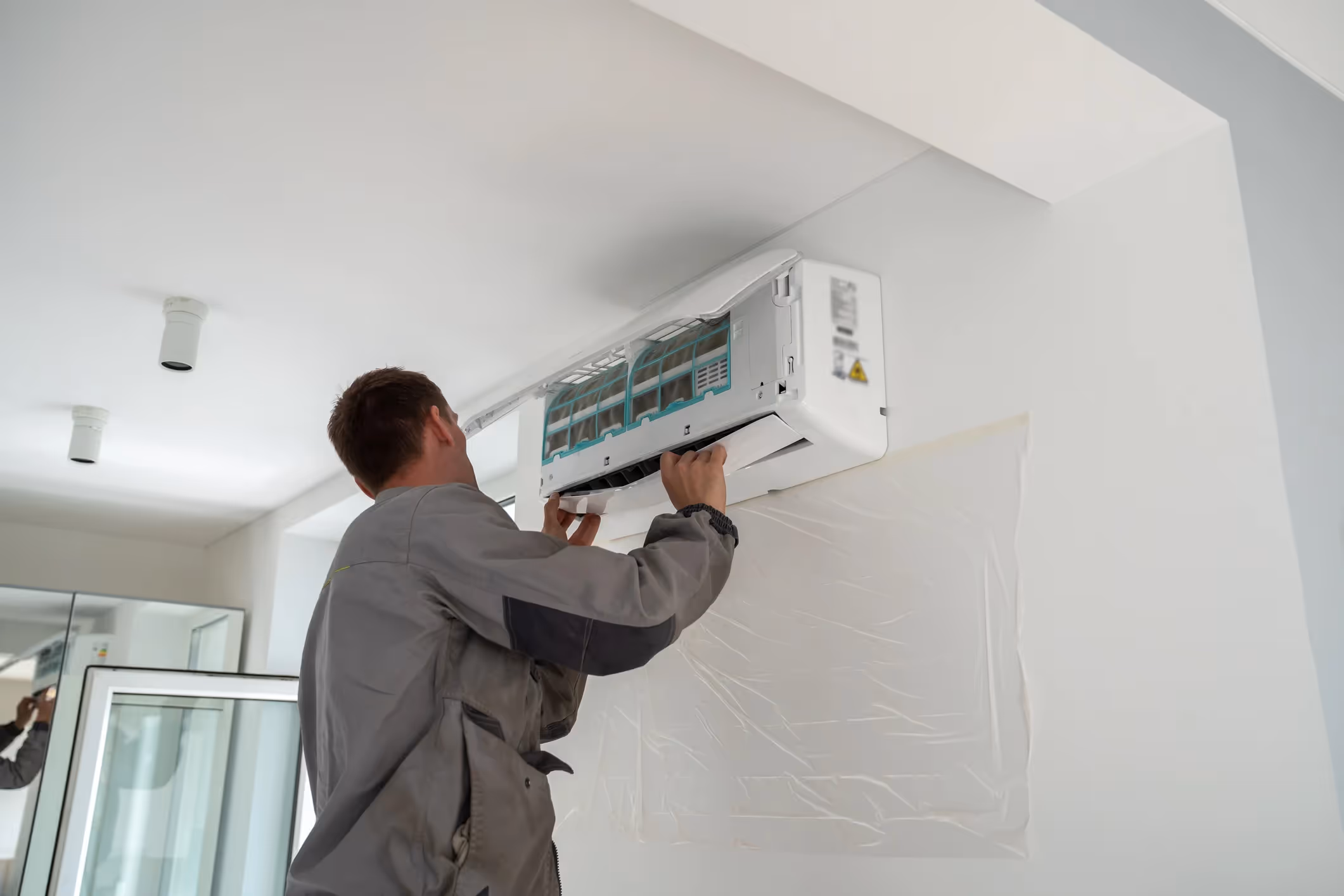 Technician servicing indoor mini-split air conditioner.