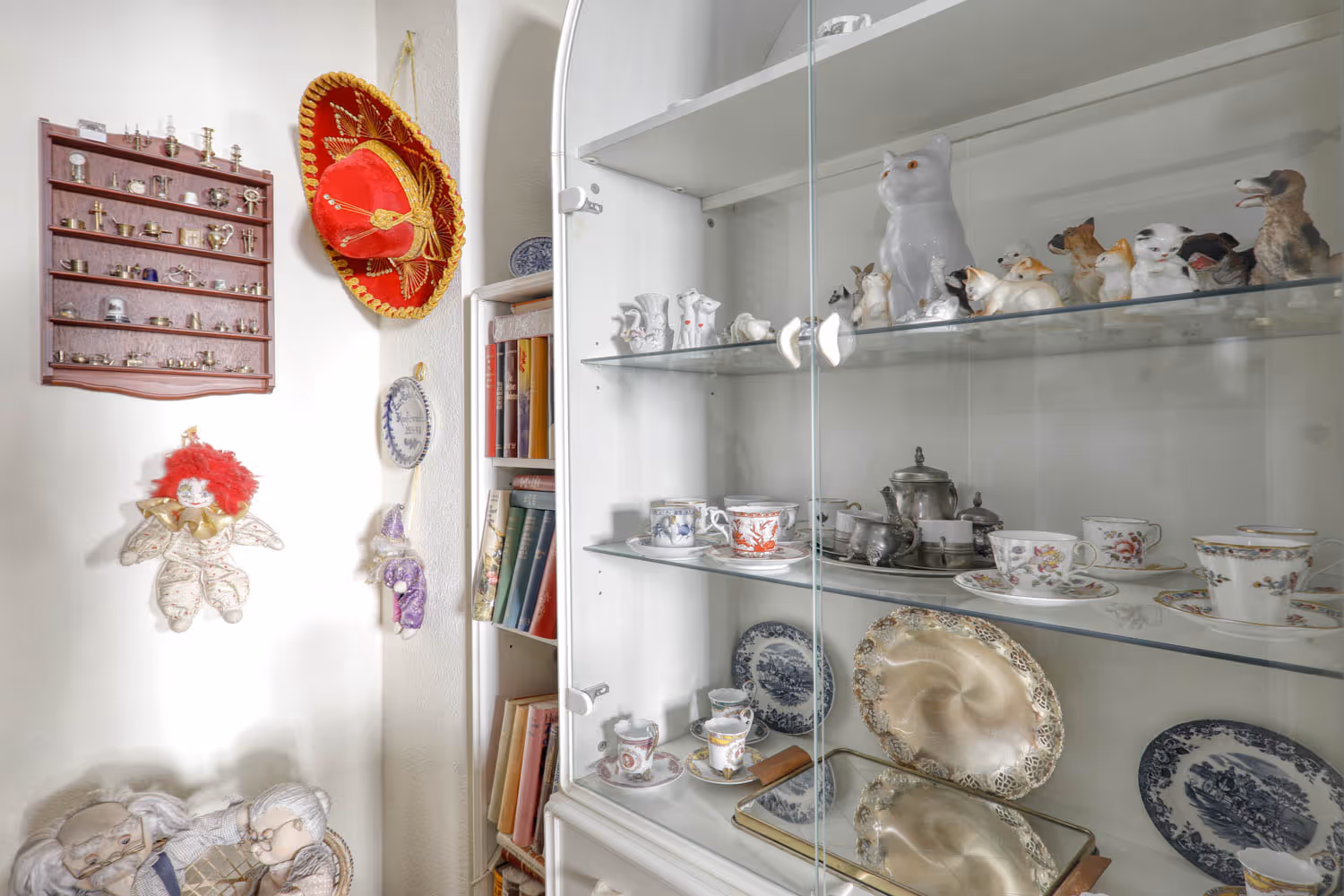 Wohnzimmervitrine mit Porzellanfiguren und Geschirr, fotografiert im Zuge einer Haushaltsaufloesung durch GRAVITAS Entrümpelungen.
