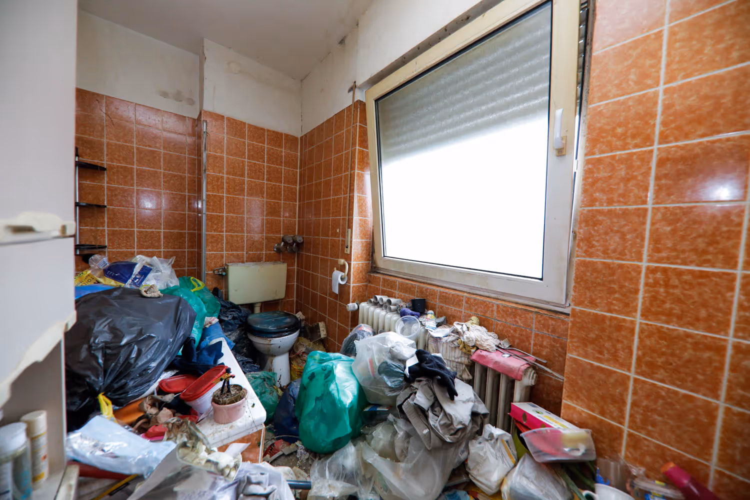 Volles Badezimmer einer Messiewohnung vor der Räumung und Grundreinigung durch GRAVITAS.