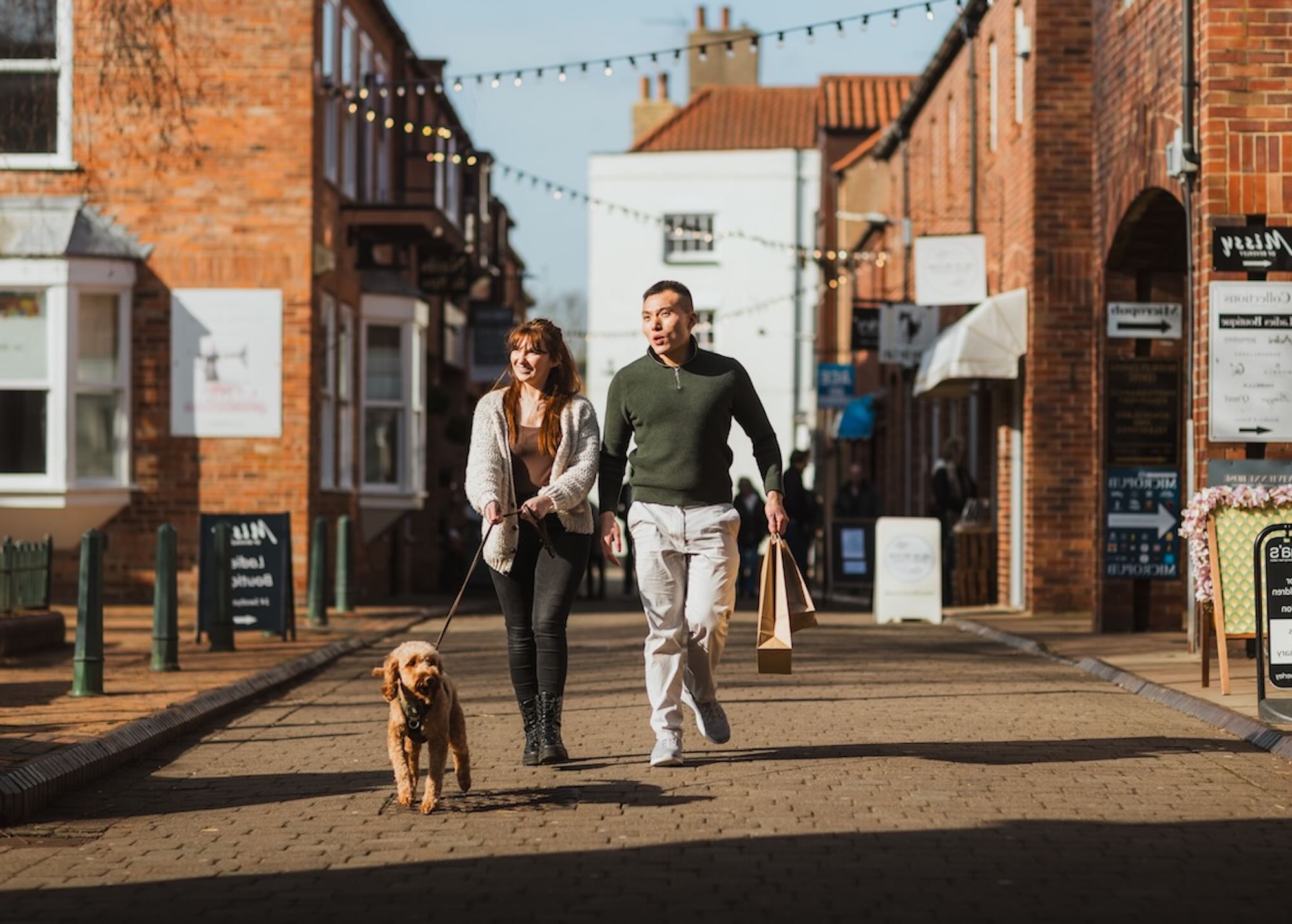 Two people walking down shopping street