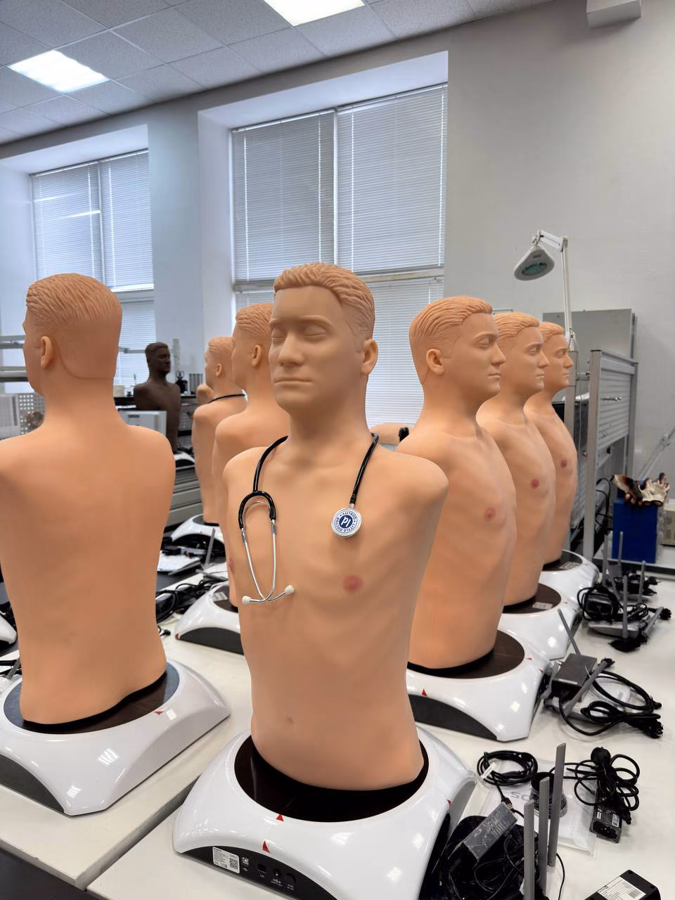 A row of torso simulators in the MedVision workshop, one wearing a stethoscope