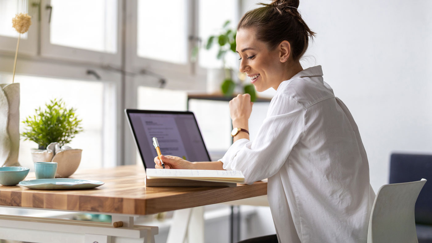 A woman looks at her computer while learning online.