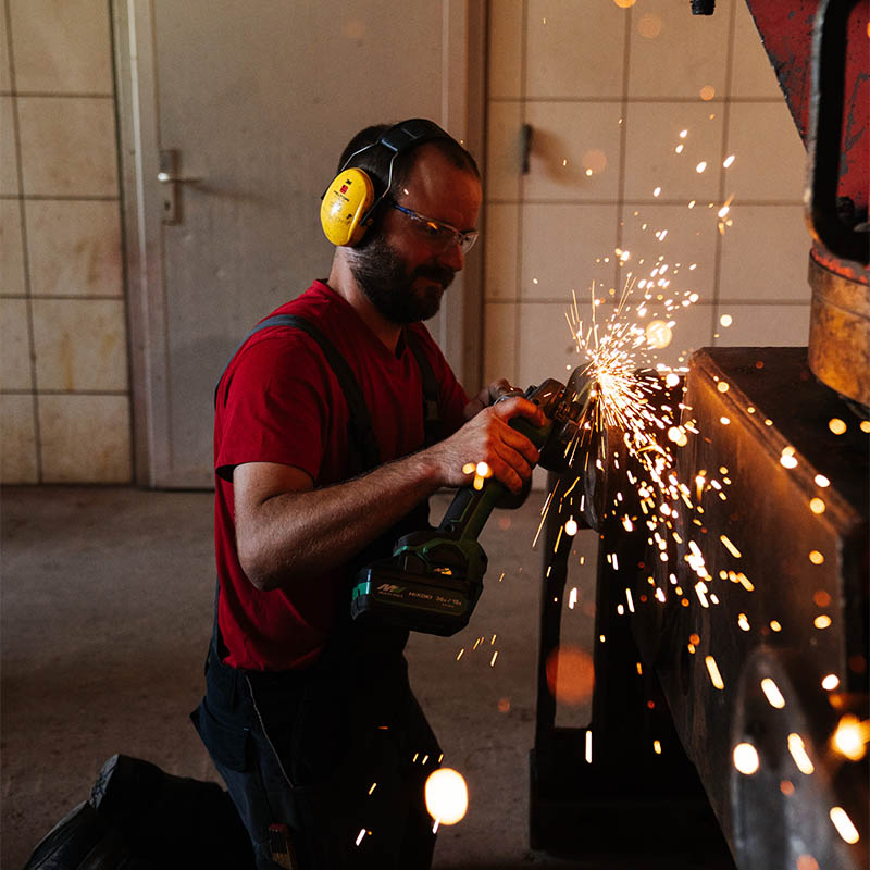 Mitarbeiter repariert Maschine mit sprühenden Funken