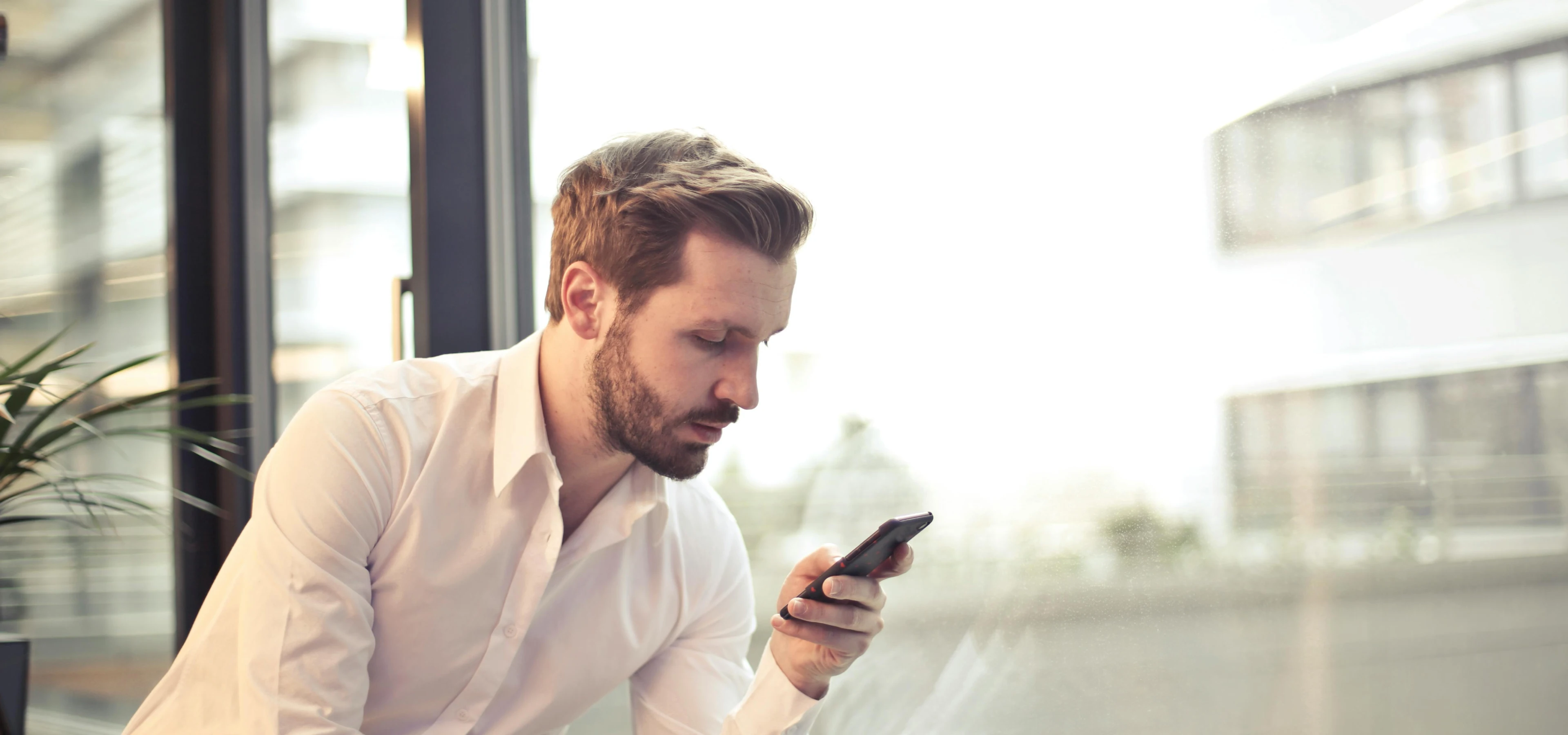 men working on his mobile phone