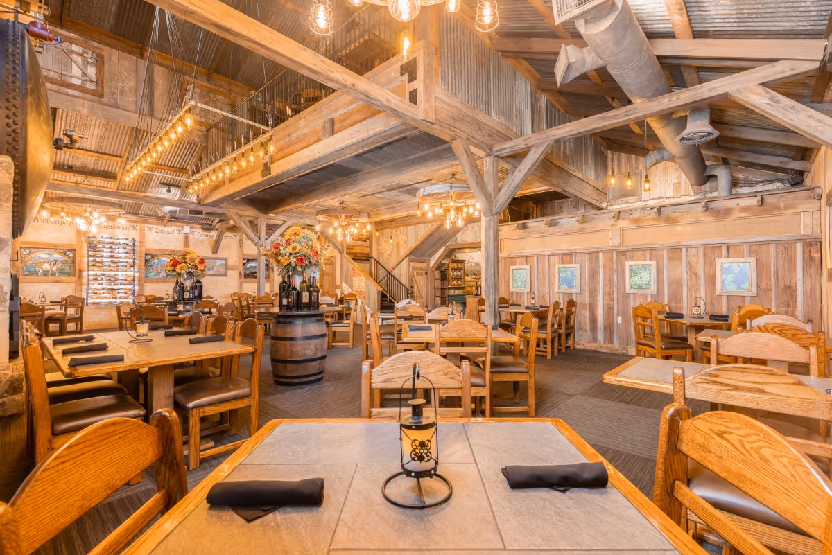 Rustic wooden restaurant interior with warm lighting and wine barrel