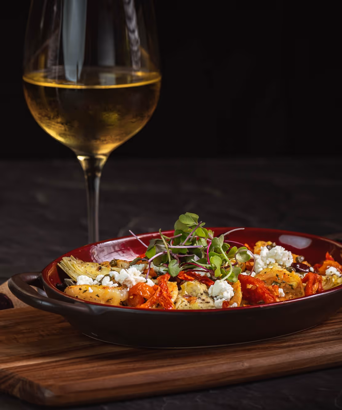 Roasted vegetables with feta cheese and microgreens, paired with white wine