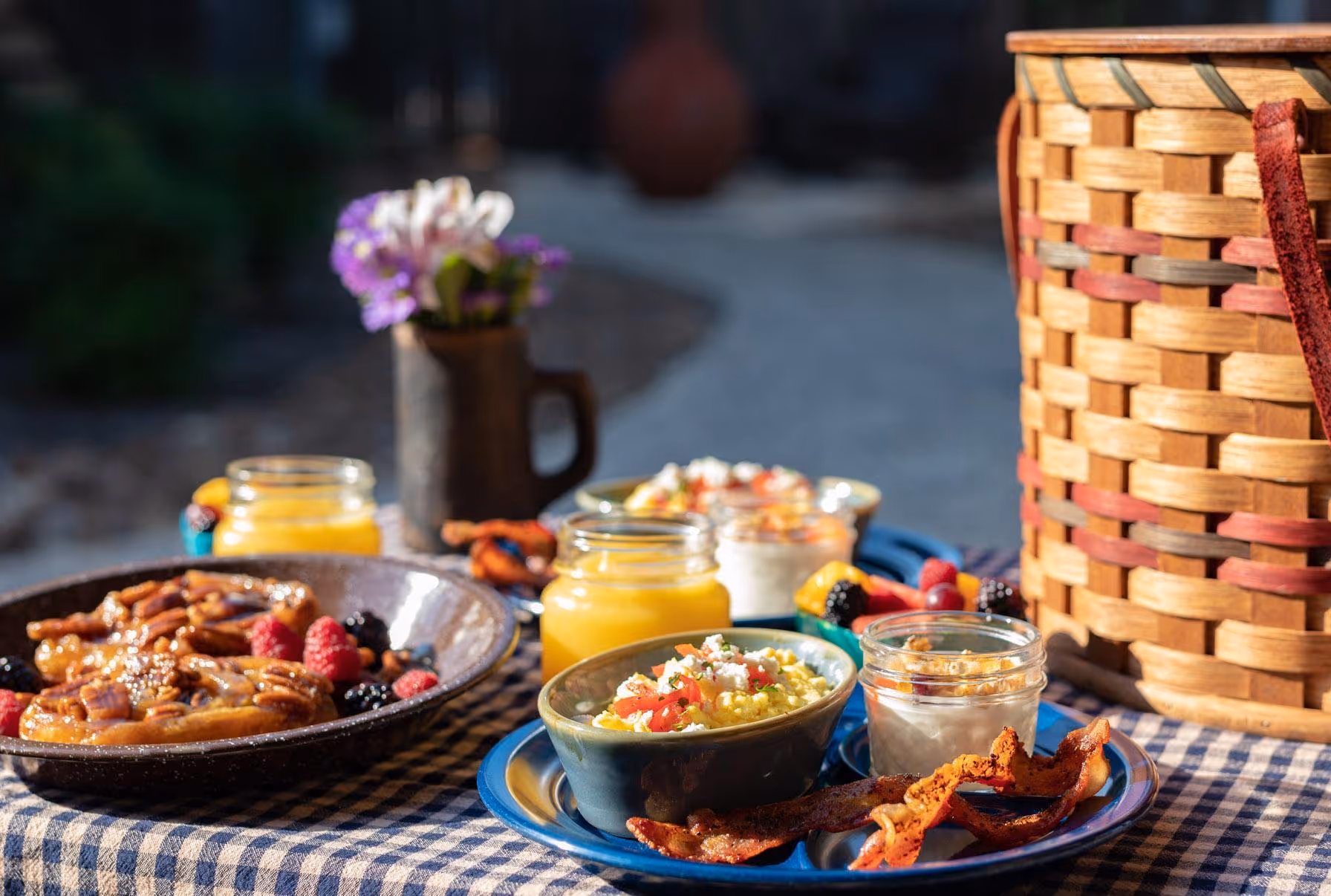 Rustic breakfast spread with cooked dishes, berries, and orange juice