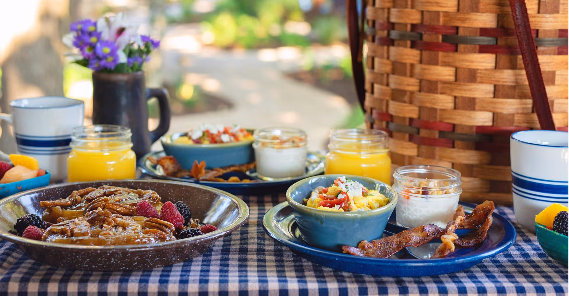 Breakfast spread with bacon, scrambled eggs, berries, and orange juice