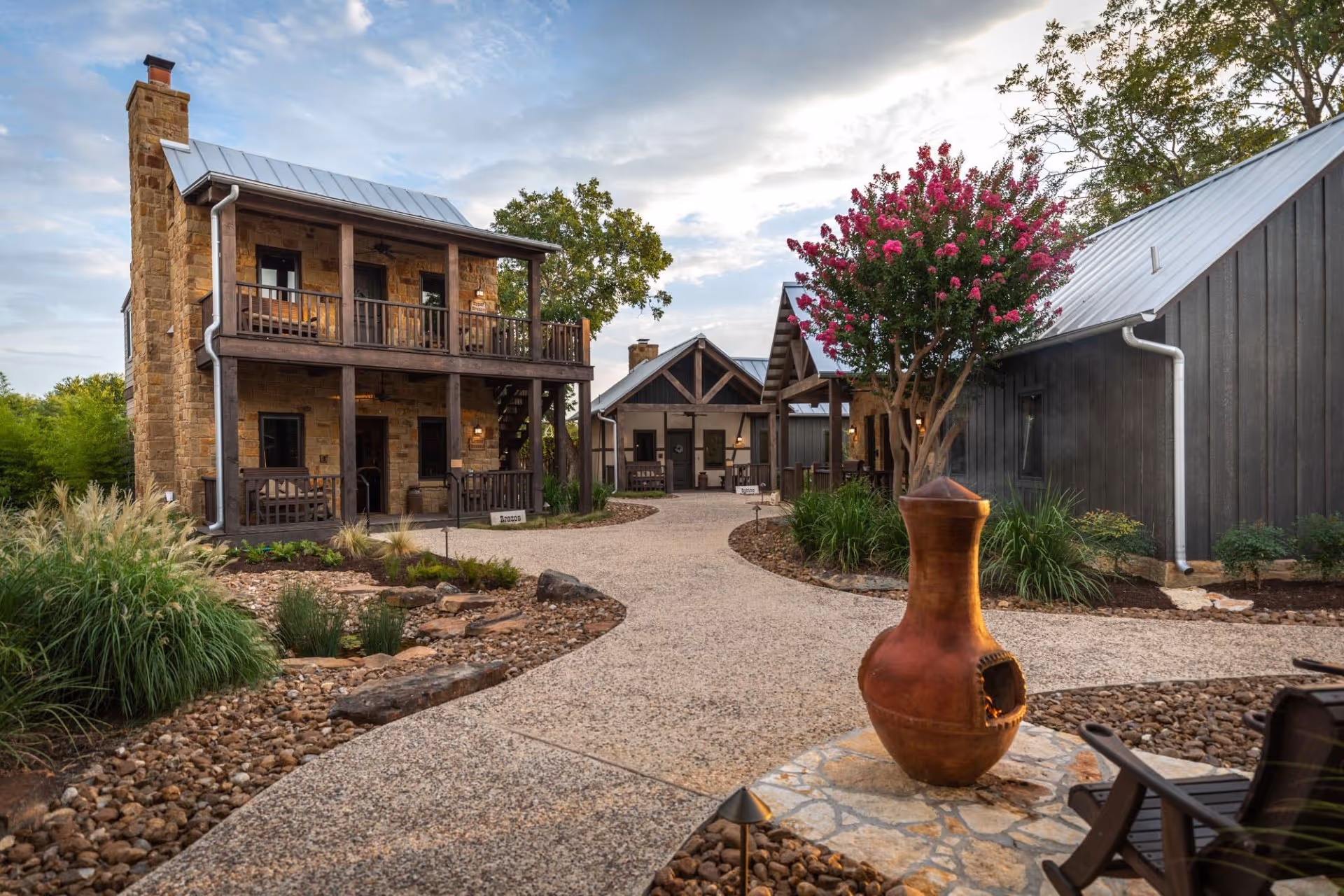 Rustic stone cottages with blooming crepe myrtle and landscaped rocky path