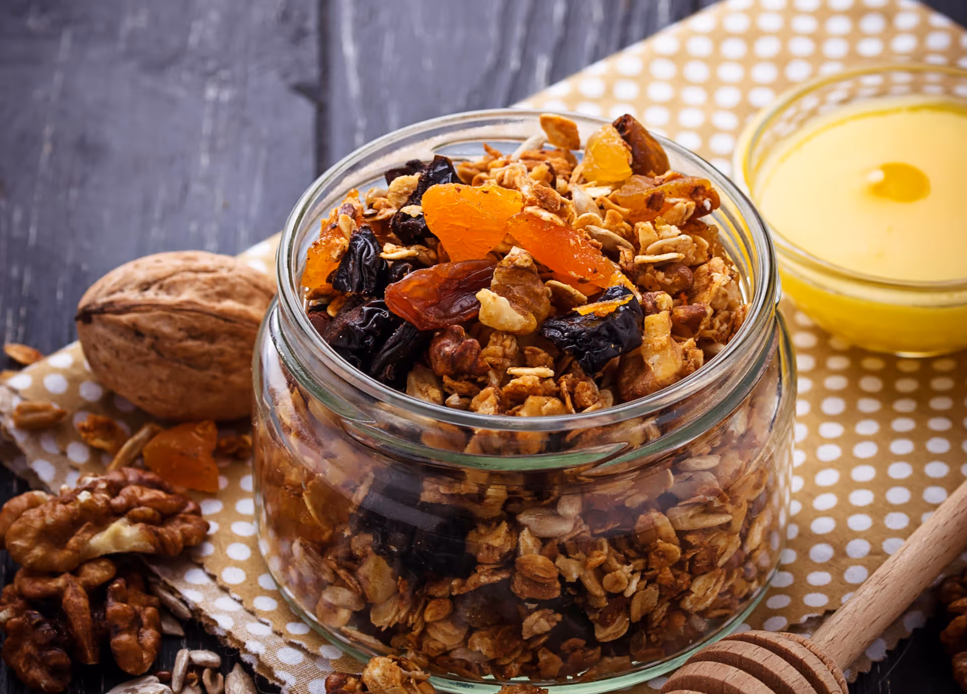 Homemade granola with dried fruits, nuts, and honey in glass jar