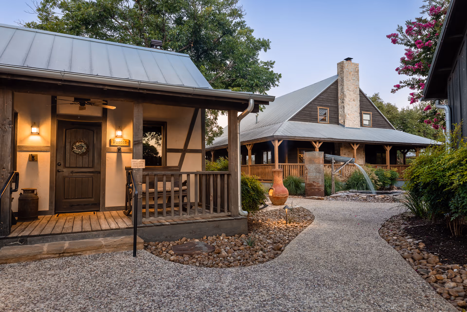 Rustic wooden cabins with stone chimney and welcoming front porch at dusk