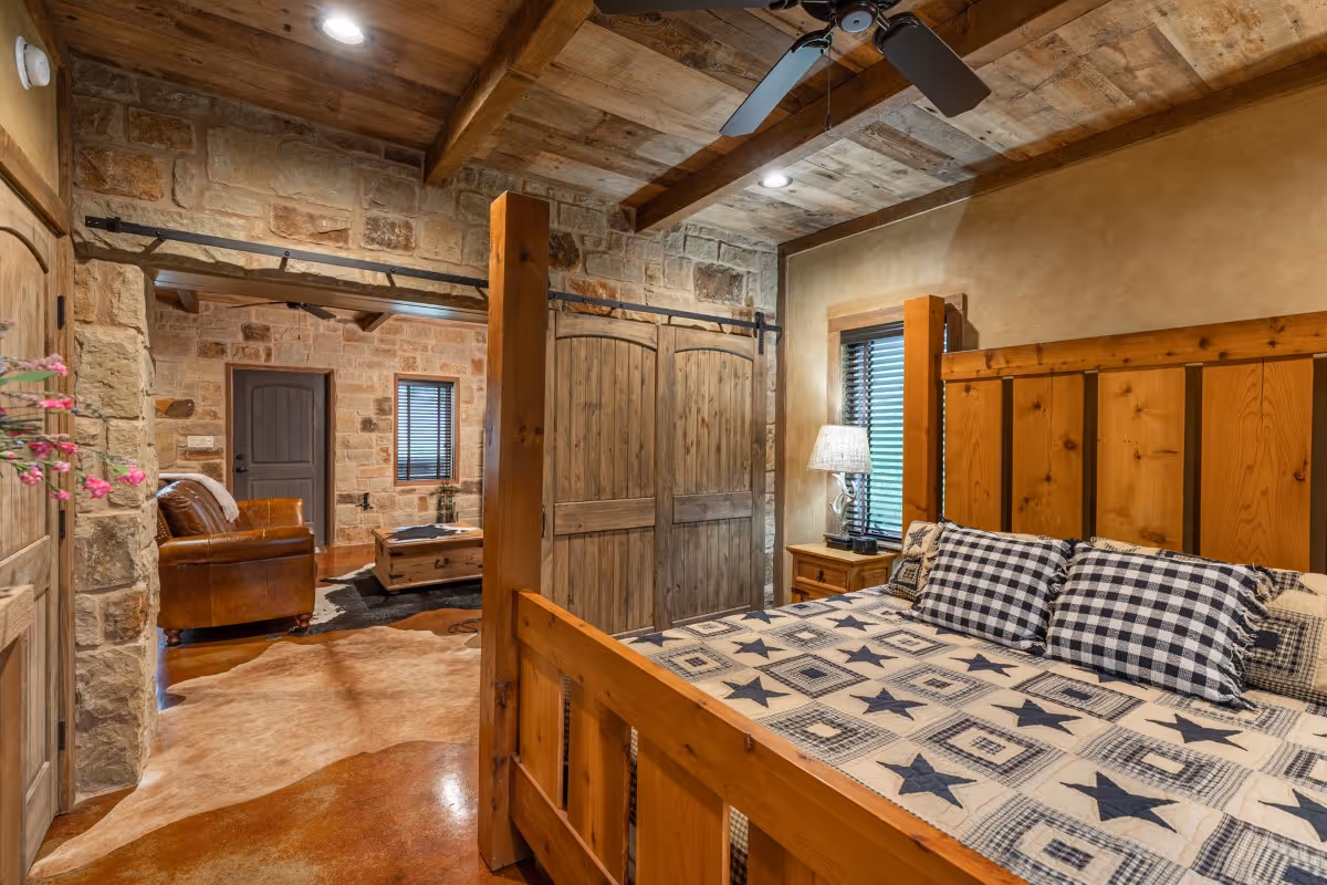 Rustic bedroom with stone walls, wooden furniture, and star-patterned bedding