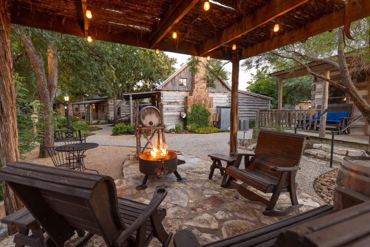 Cozy outdoor fire pit area with wooden chairs and rustic cabins