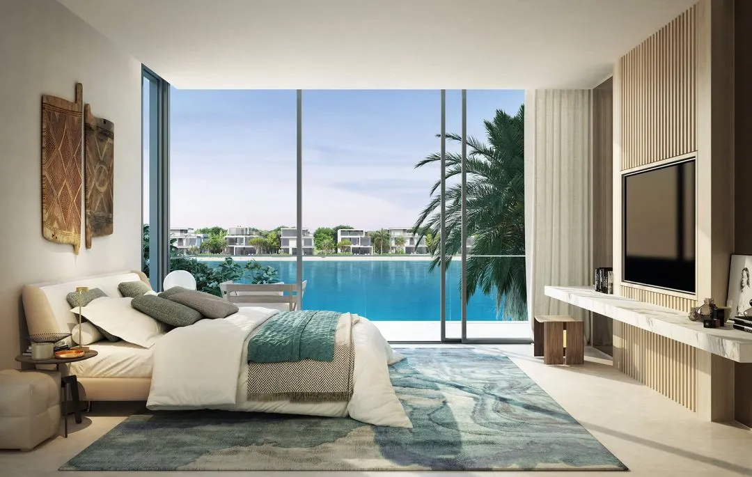 A luxurious bedroom with a balcony offering a scenic view of the sea.