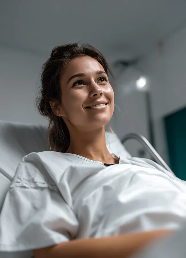 Female patient resting in hospital bed wearing medical gown