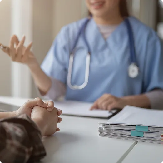 SmartCare Rx Pharmacy healthcare provider in blue scrubs with a stethoscope consulting with a patient, discussing medical records and patient care